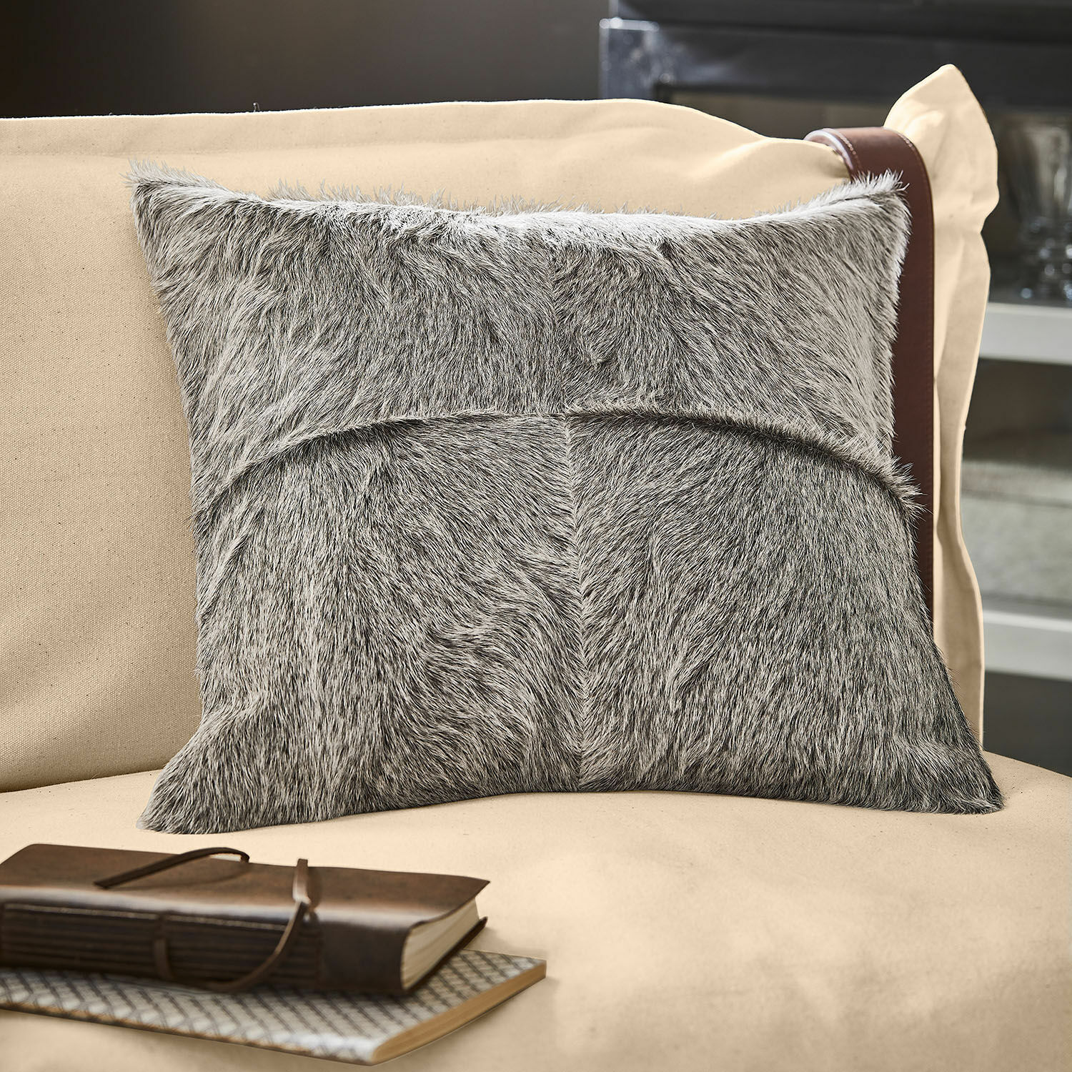 Kissenhülle Nymarion Graues Dekokissen aus Fellmaterial auf beigem Sofa, stilvolles Wohnaccessoire für Gemütlichkeit