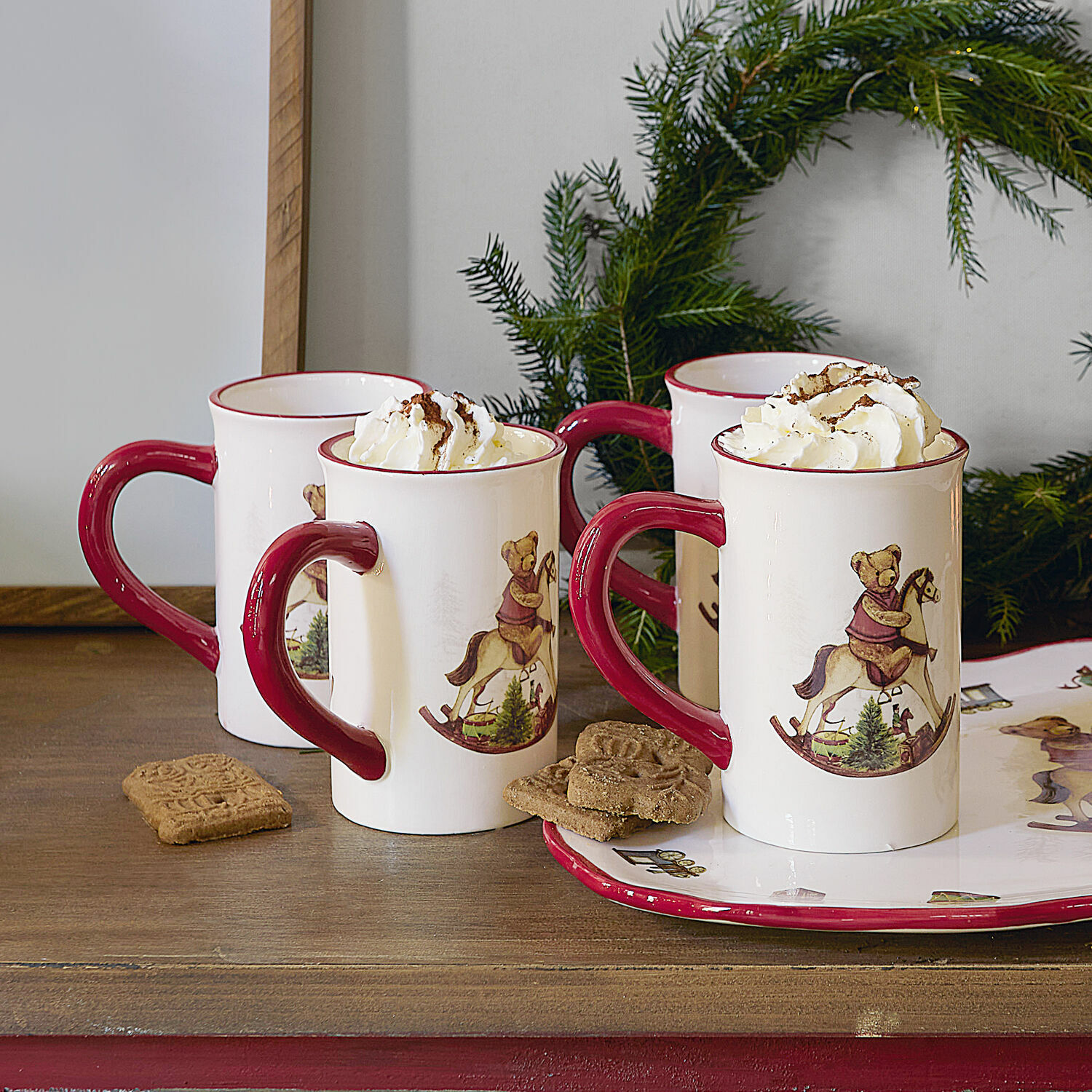 Tasse 4er Set Troms Keramiktassen mit rotem Henkel und Bärenmotiv auf Schaukelpferd, gefüllt mit Sahne, weihnachtlich dekoriert