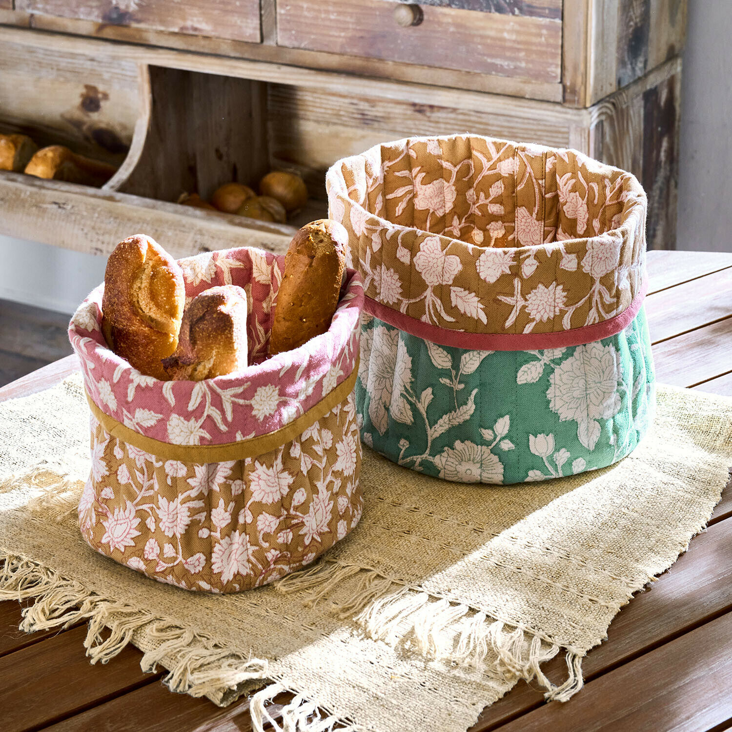 Korb 2er Set Fleuronnes Zwei dekorative Baumwollkörbe mit floralem Muster in Rosa, Braun und Grün für Brot auf Holztisch