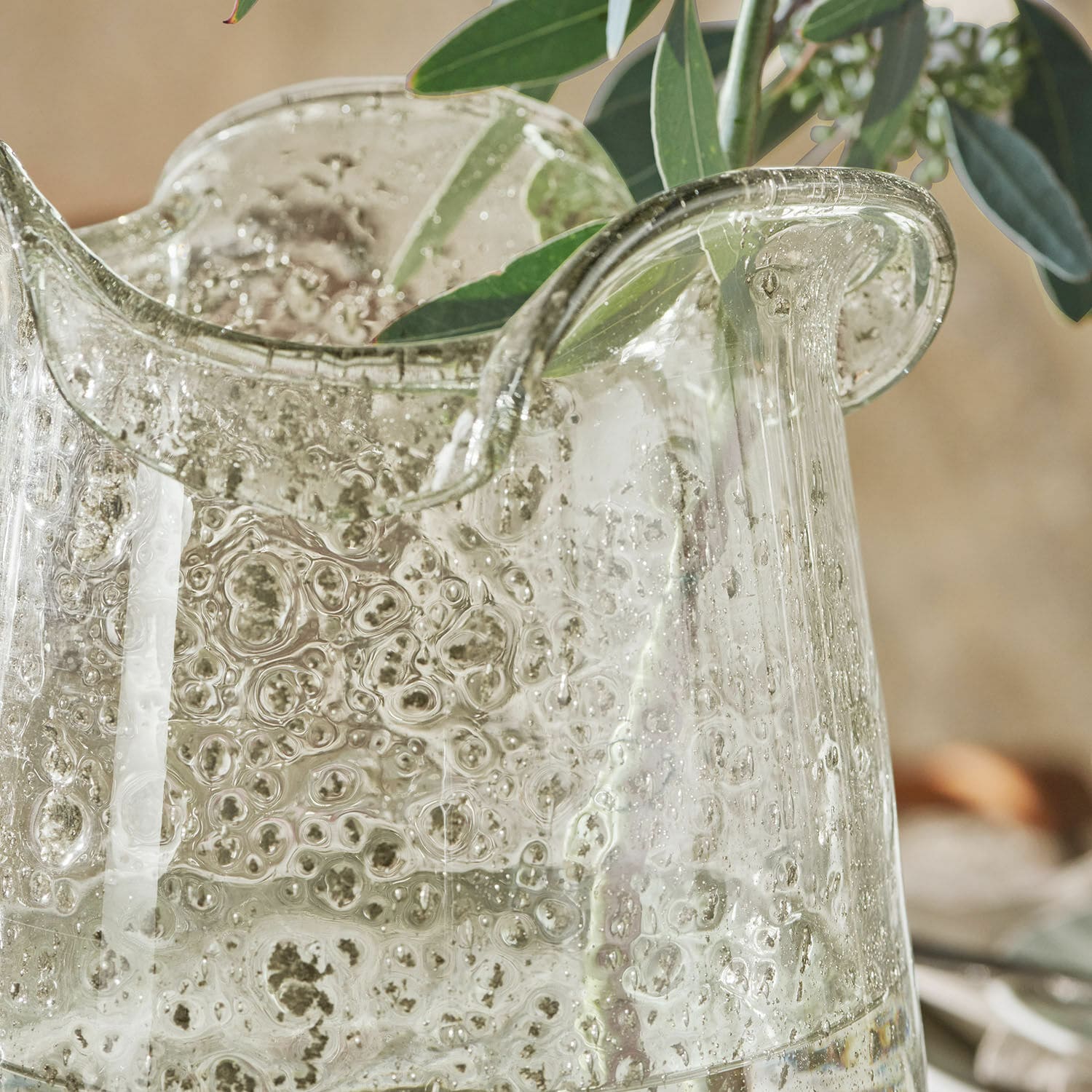 Transparente Glasvase mit Luftblasen und grünen Blättern, dekoratives Kunstglas für Innenräume