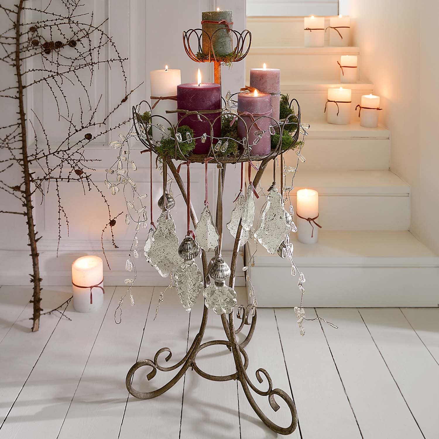 Metallkerzenständer mit blattförmigen Anhängern und violetten Kerzen im rustikalen Stil