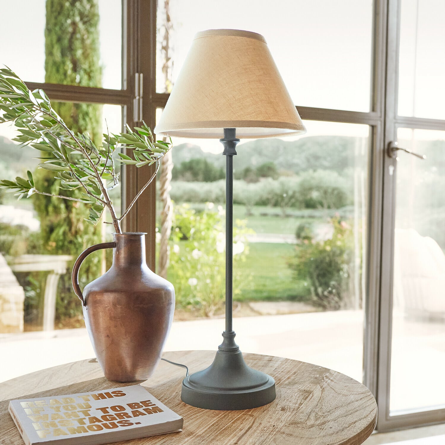 Tischlampe Swindon Tischlampe mit Metallfuß und beigem Lampenschirm auf Holztisch mit Vase und Buch
