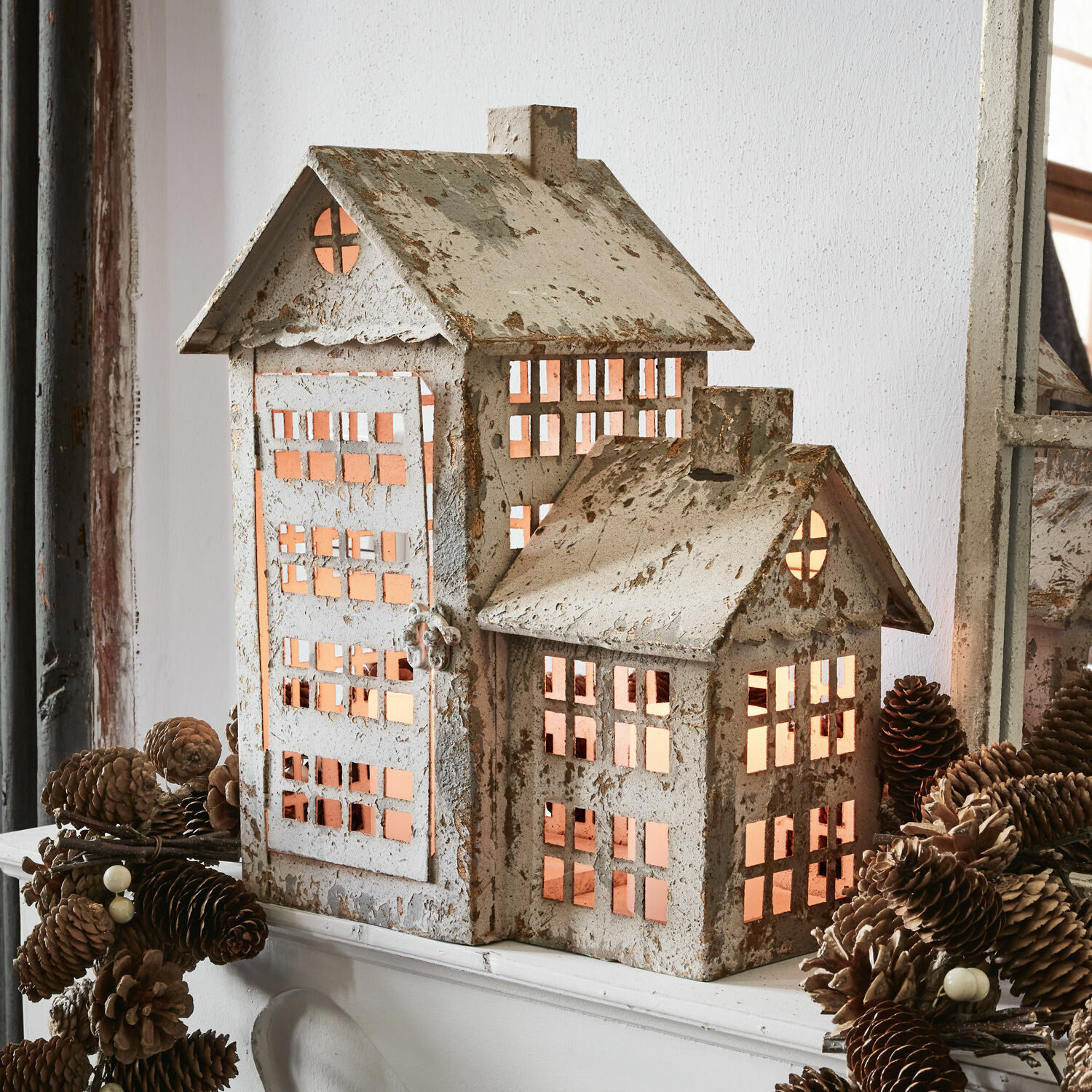 Dekorativer Haus-Lampion aus Metall in verwittertem Weiß mit warmem Licht im Inneren