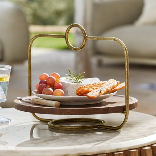 Vintage Käsehalter aus Holz und Metall mit Snacks und Trauben auf Marmorplatte