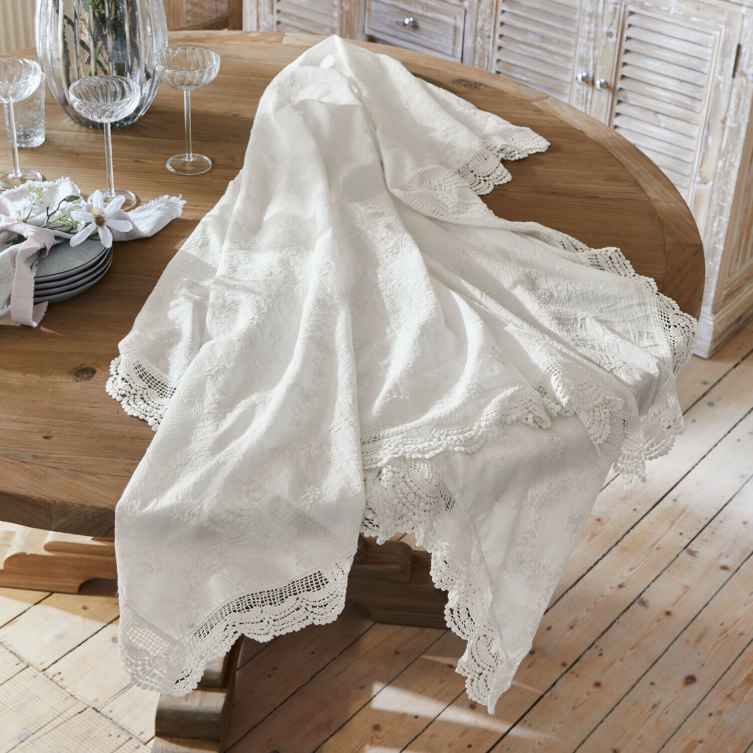 Weißer Tischläufer mit Spitzenrand auf Holztisch, elegante Tischdekoration im Esszimmer