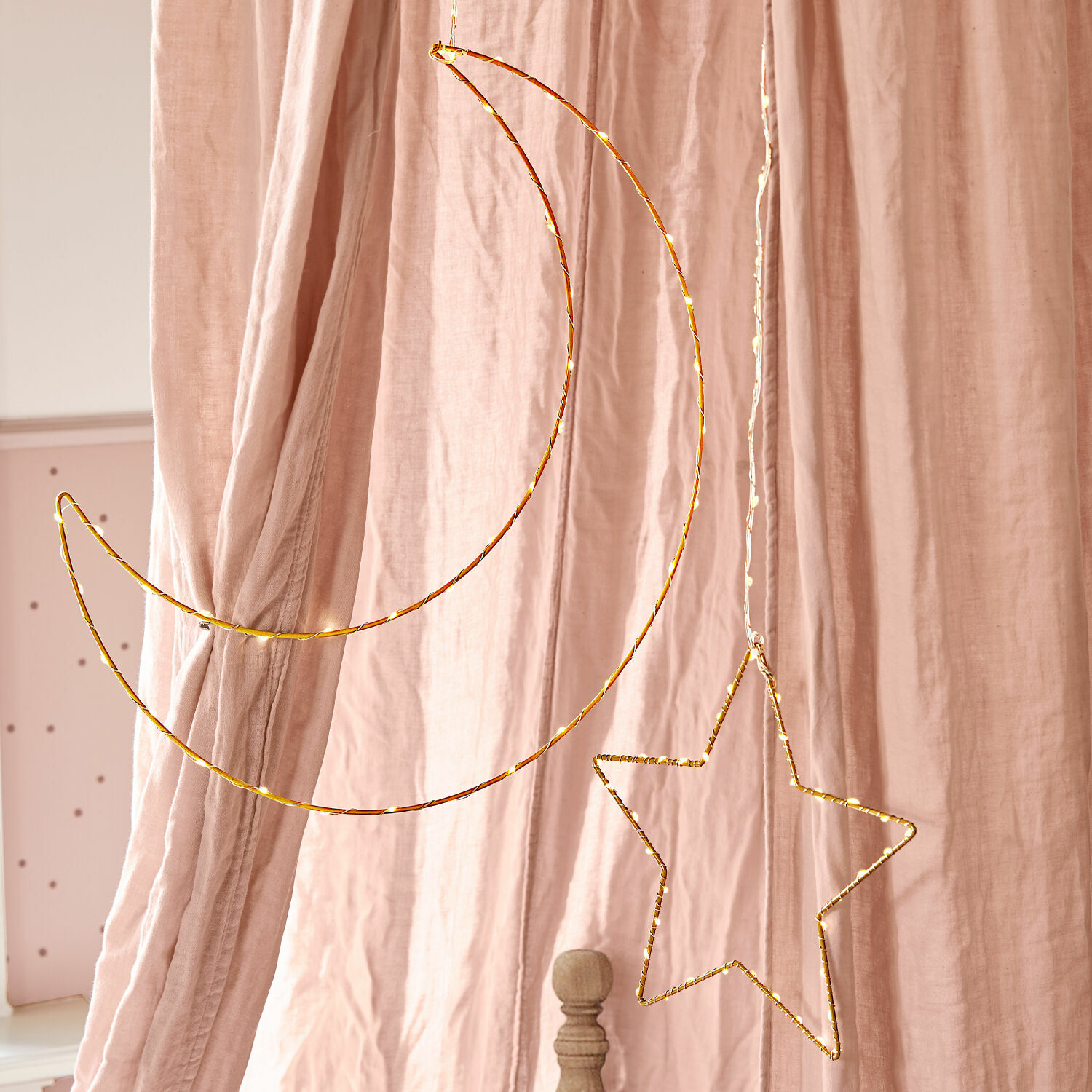 LED-Leuchtdeko 2er Set Padden Hängende Deko aus goldenem Metalldraht in Mond- und Sternform vor rosa Vorhängen