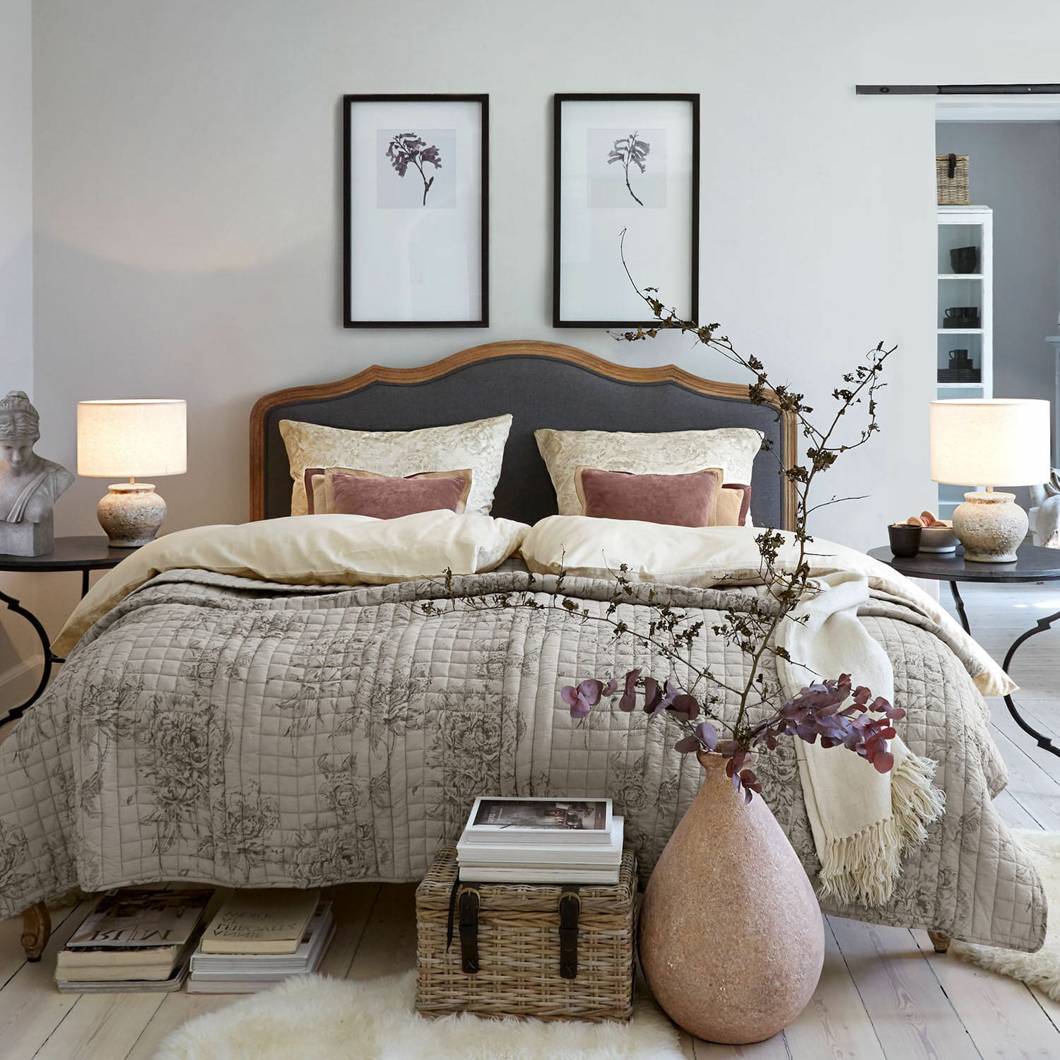 Bettwäsche Bravonea Gemütliches Schlafzimmer mit Holzbett und grauem Polster, beige Steppdecke mit floralem Muster, natürliche Deko