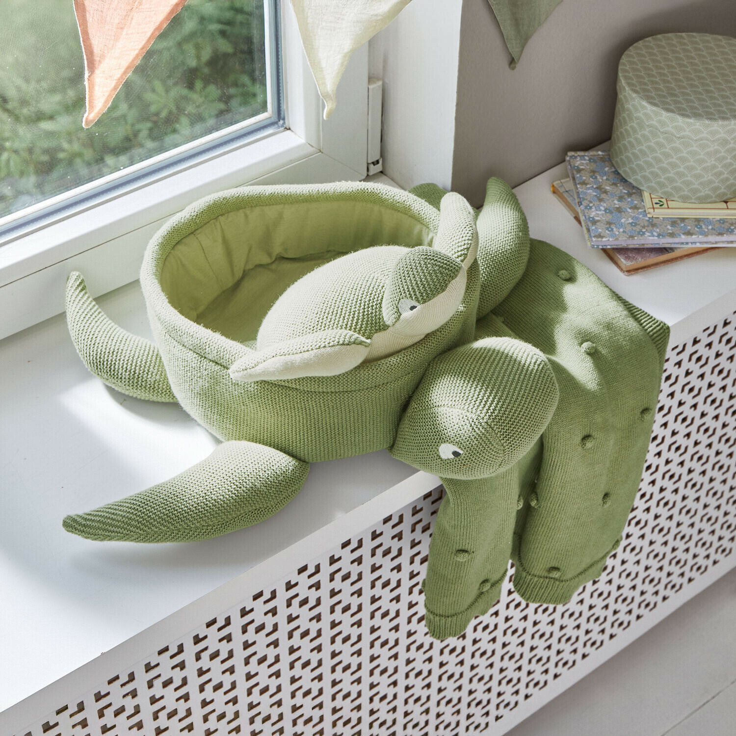 Weiches, grünes, gestricktes Schildkrötenkissen auf Fensterbank, dekoratives Kinderzimmer-Accessoire