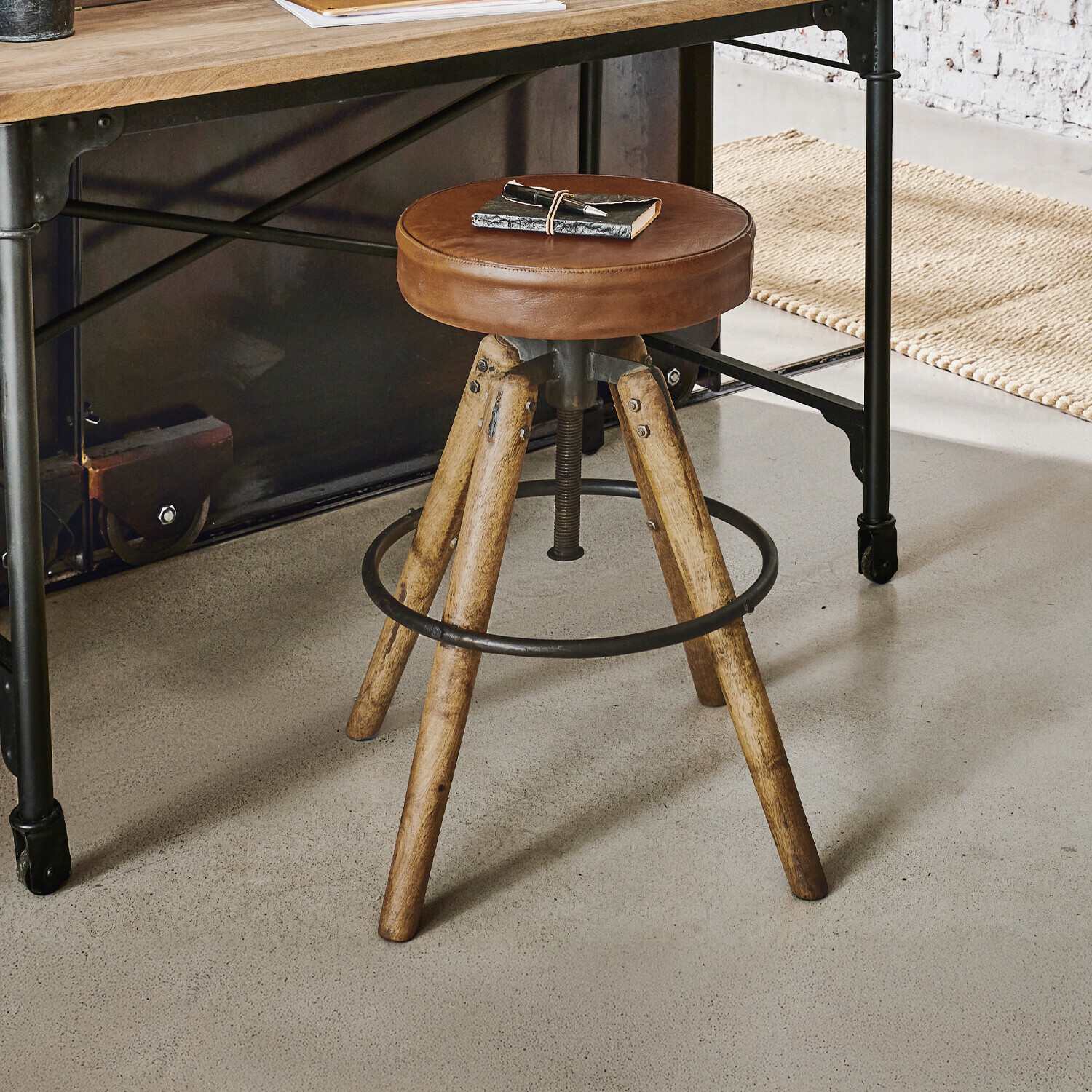 Hocker Twist Barhocker mit braunem Lederpolster und Holzbeinen im Industrie-Design