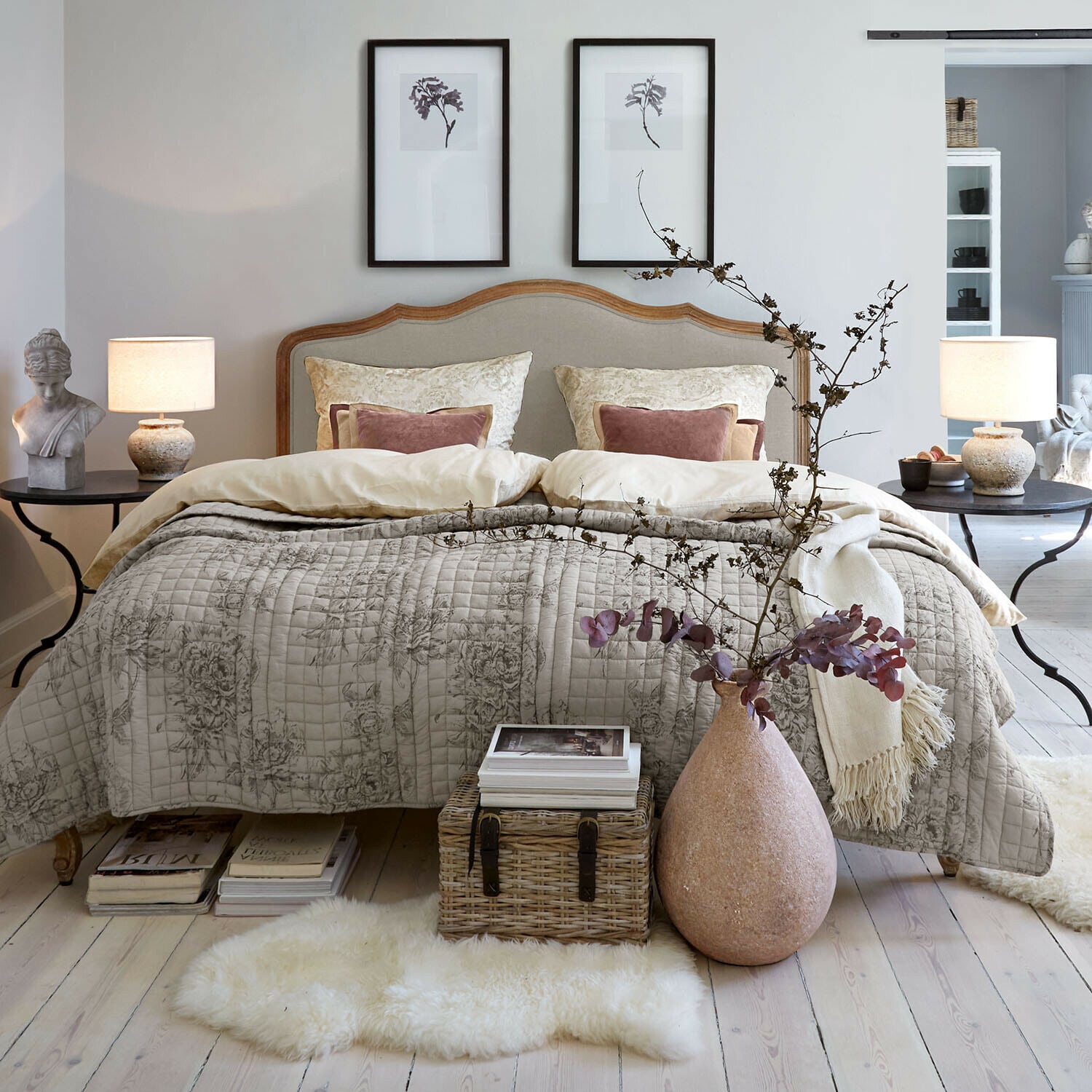 Bett Serravalle Gemütliches Schlafzimmer mit Bett in beiger Bettwäsche und dekorativer Steppdecke mit Blumenmuster