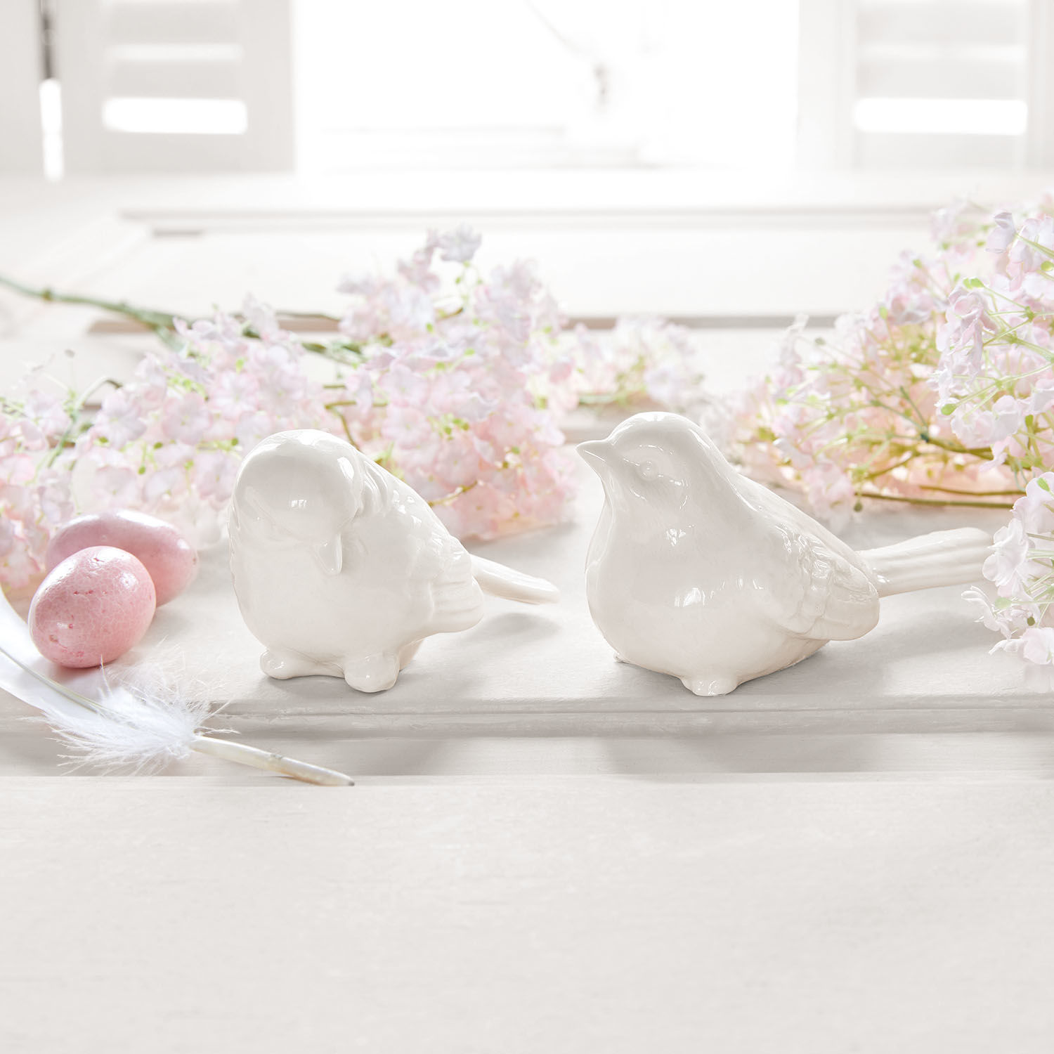 Vogel 2er Set Piparills Zwei weiße Keramikvogel-Figuren auf hellem Untergrund mit rosa Blumen und Dekoeiern