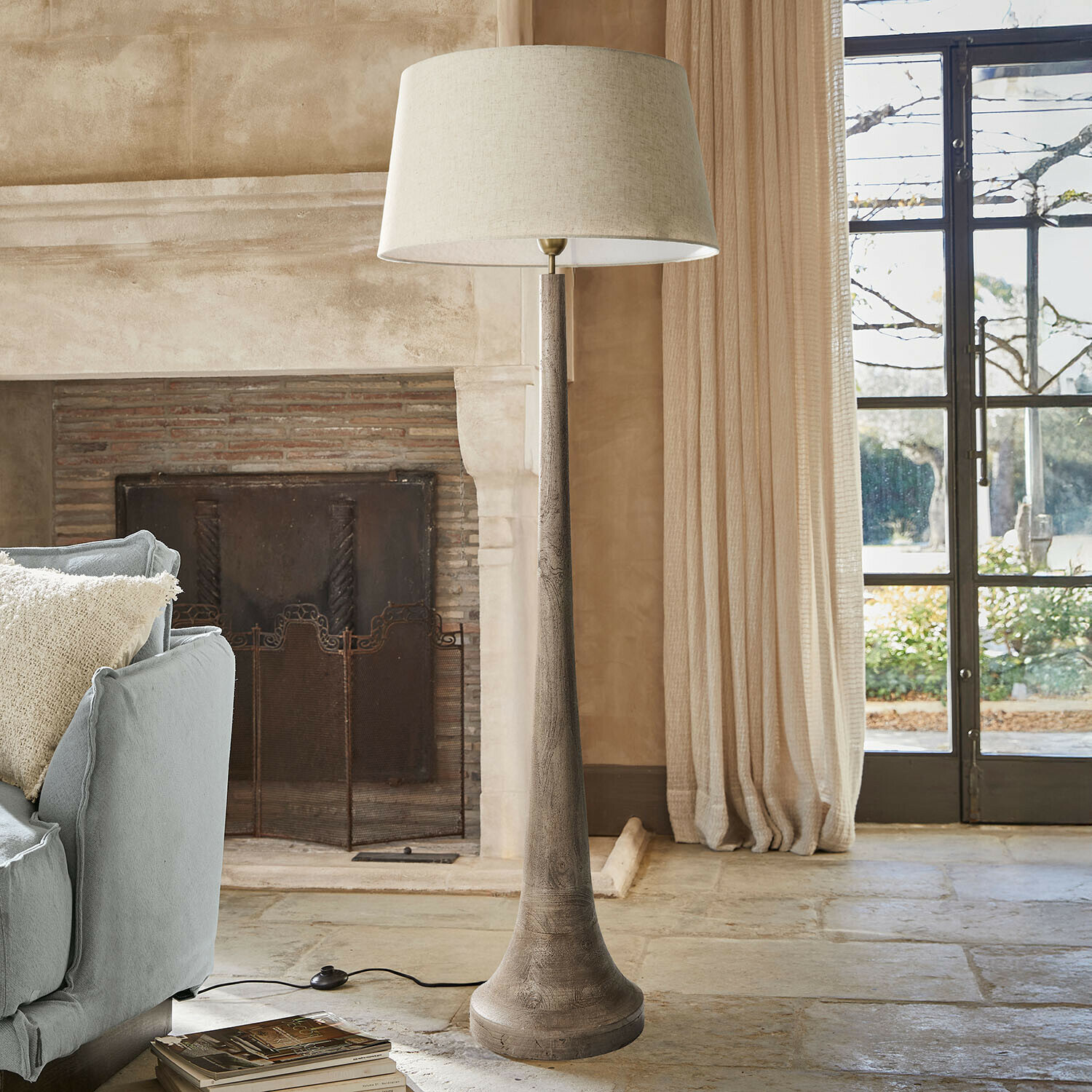 Stehlampe Helsfjord Stehlampe mit Holzfuß und beigem Lampenschirm in gemütlichem Wohnzimmer mit Kamin und Sofa