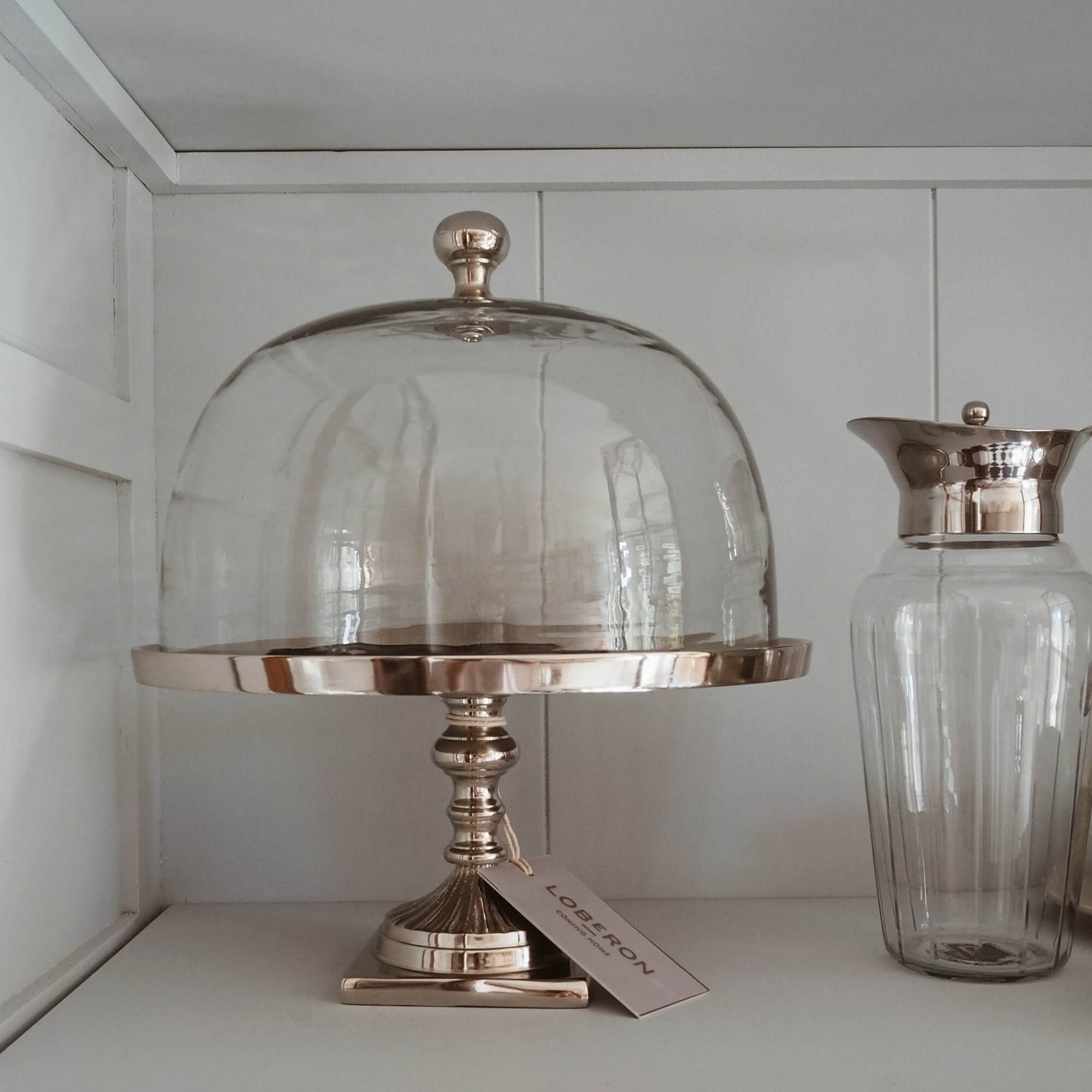 Glasglocke auf goldenem Metallständer zum Servieren von Kuchen und Desserts im Slow-Living-Stil