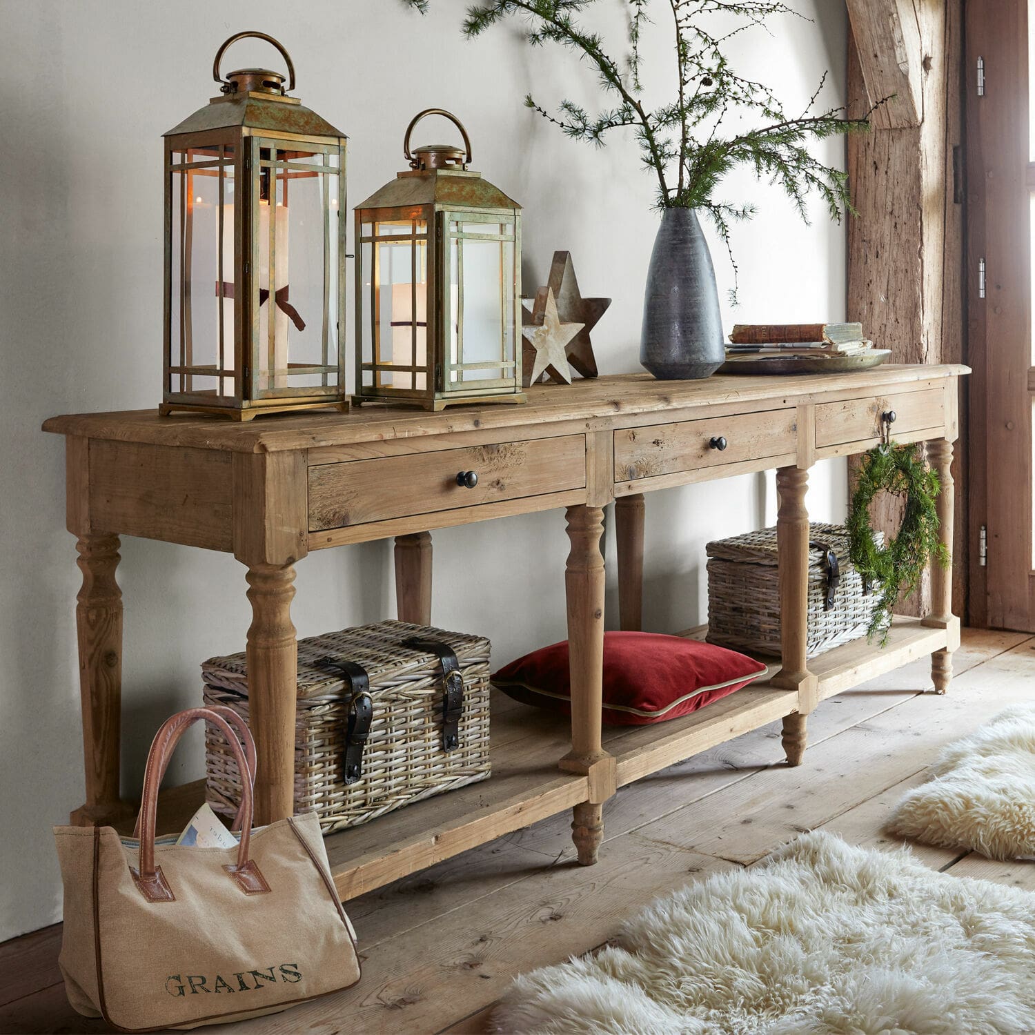 Konsole Misérieux Holzkonsole mit drei Schubladen, dekorativen Laternen und Korb aus Weide in gemütlichem Raum