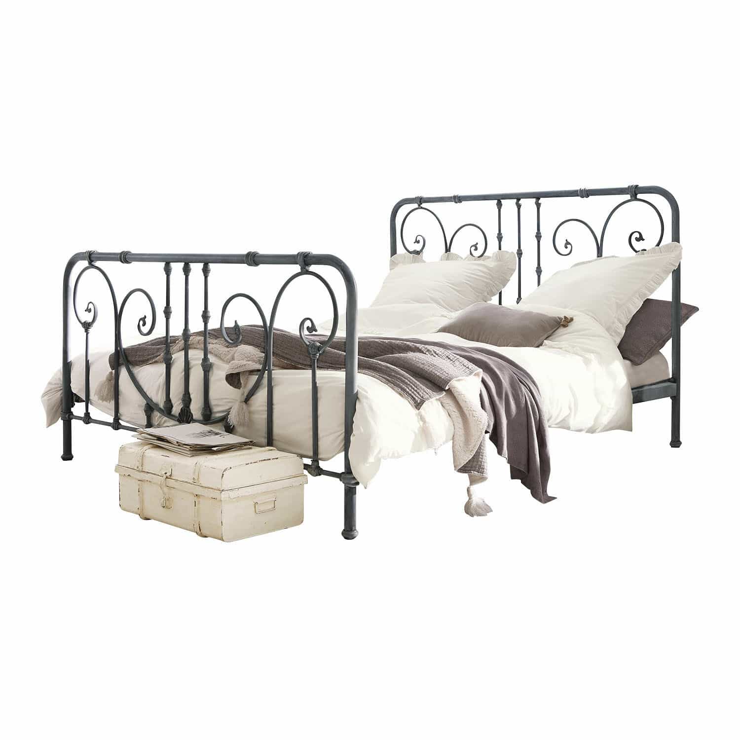 Bett Genouillé Vintage Metallbett in Grau mit dekorativen Verzierungen, weißer Bettwäsche und grauen Decken