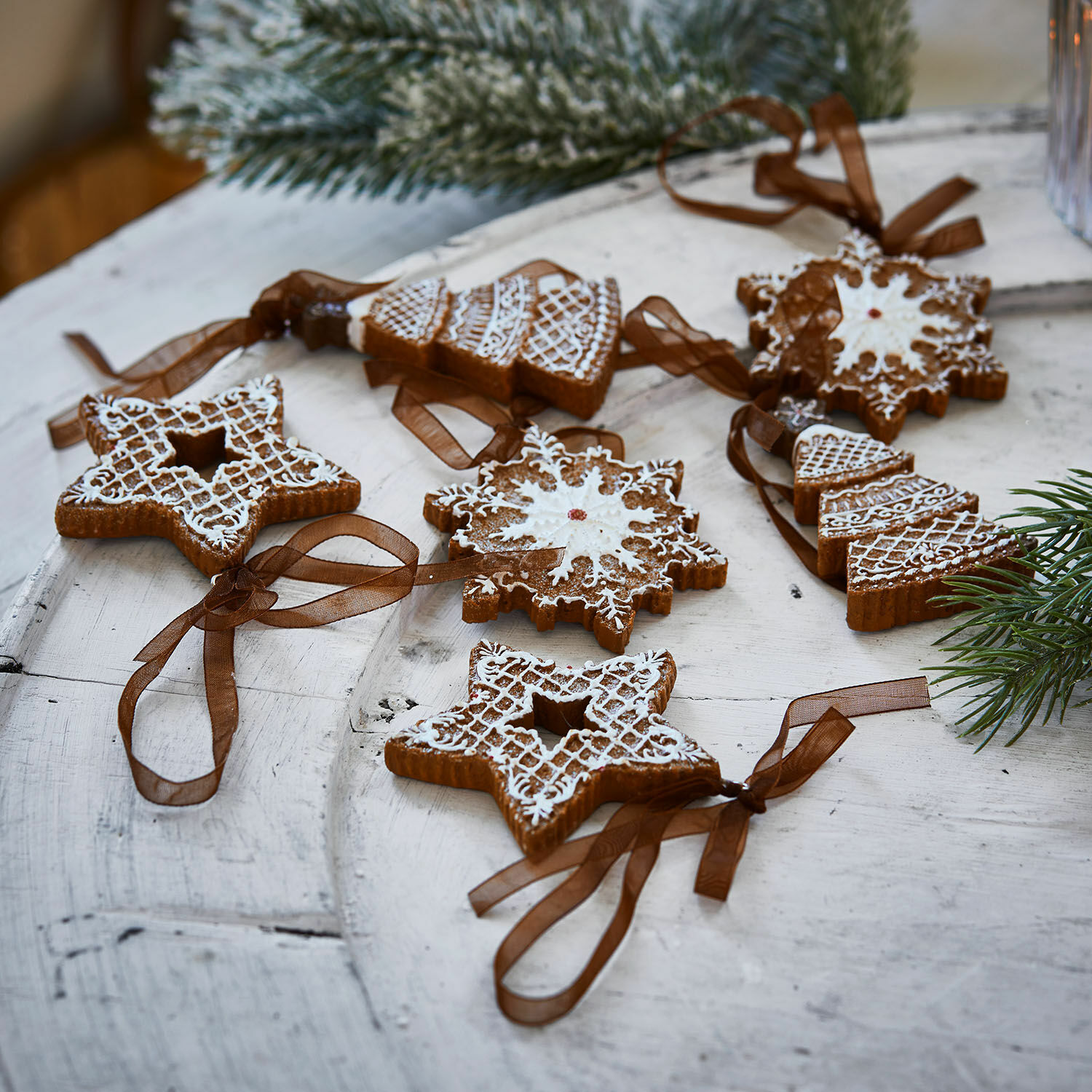 Anhänger 6er Set Chimayo Set aus Lebkuchen-Weihnachtsanhängern mit weißer Glasur und braunen Bändern auf Holztisch