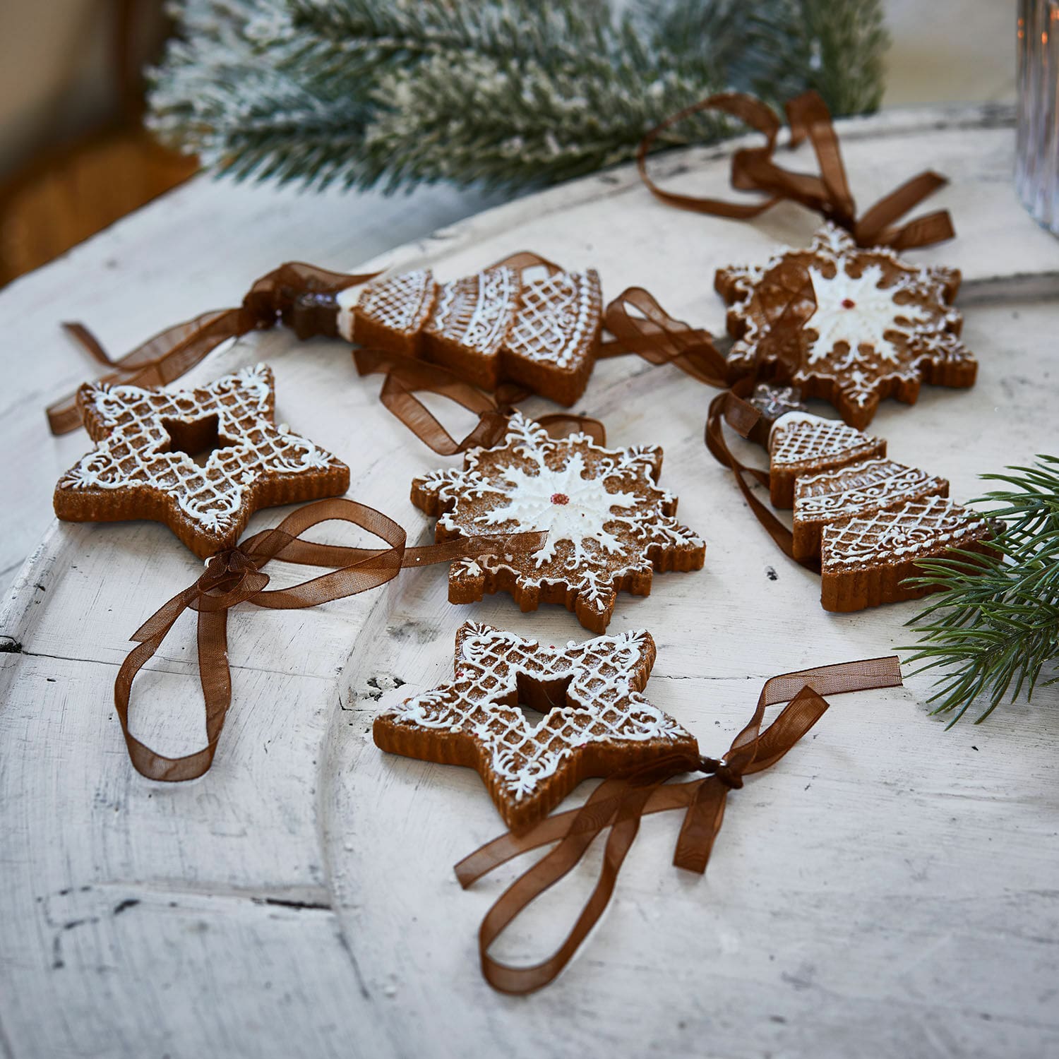 Anhänger 6er Set Chimayo Set aus Lebkuchen-Weihnachtsanhängern mit weißer Glasur und braunen Bändern auf Holztisch