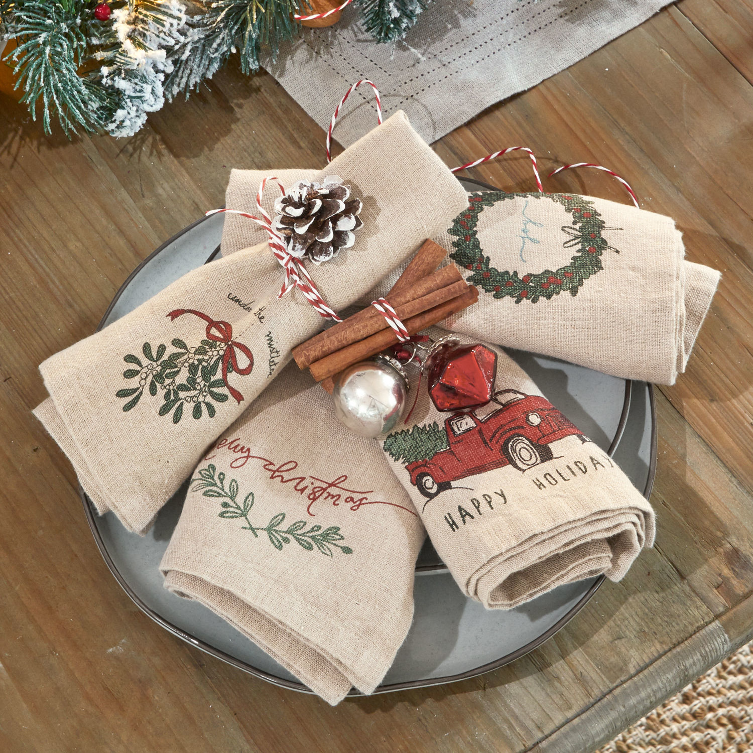 Serviette 4er Set Camon Leinen-Weihnachtsservietten mit rotem Auto- und Kranzmotiv auf rustikalem Holztisch