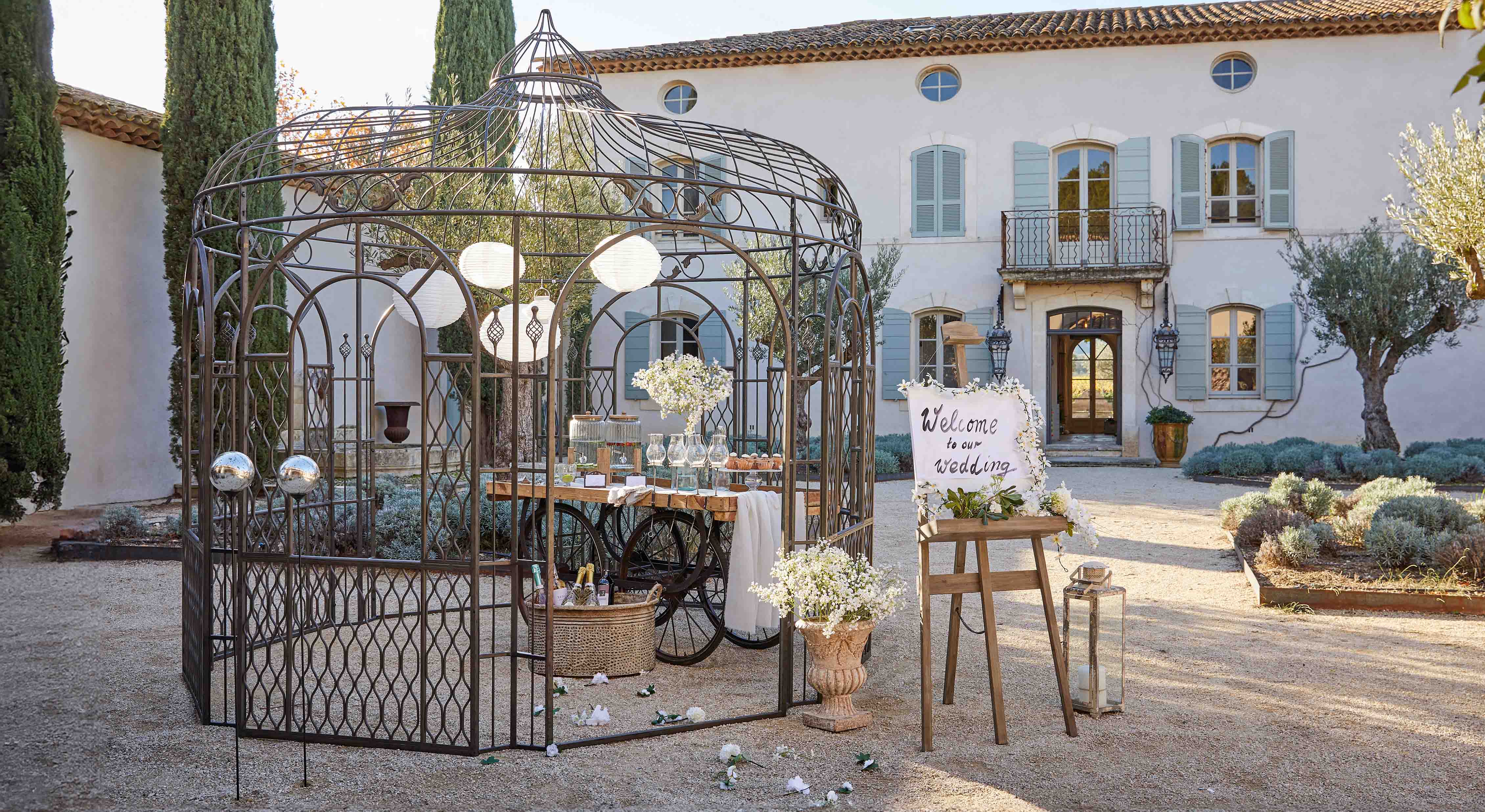 Metallpavillon mit dekorativem Muster im Garten mit Tisch und Blumen für eine Hochzeitsfeier