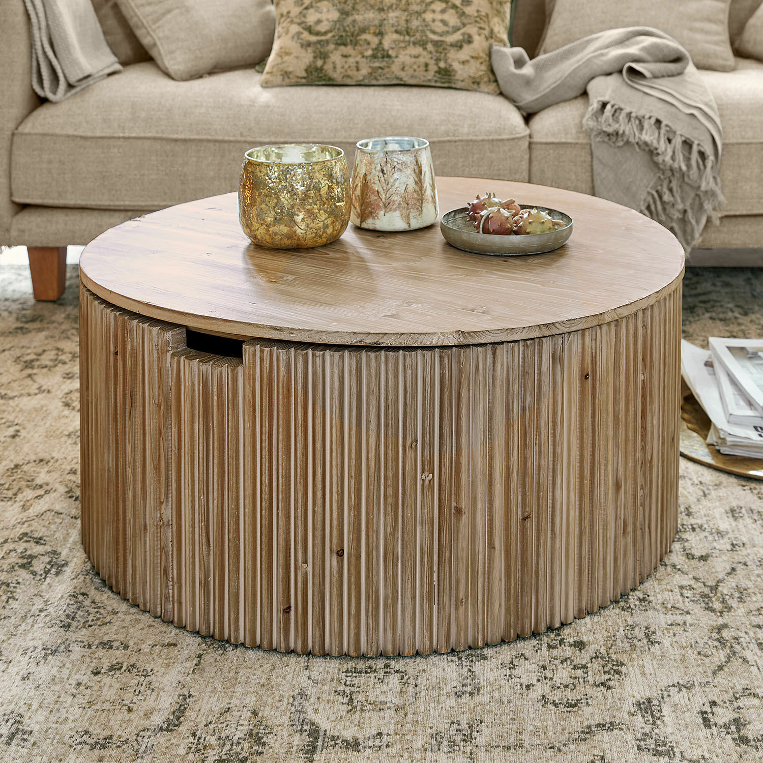 Couchtisch Saintouré Runder Couchtisch aus Holz in Naturfarbe auf Teppich vor beigem Sofa mit Decke