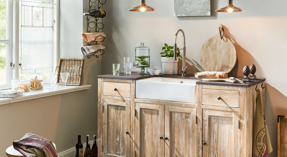 Rustikale Holzküche mit weißem Keramikspülbecken und schwarzer Arbeitsplatte im Vintage-Stil