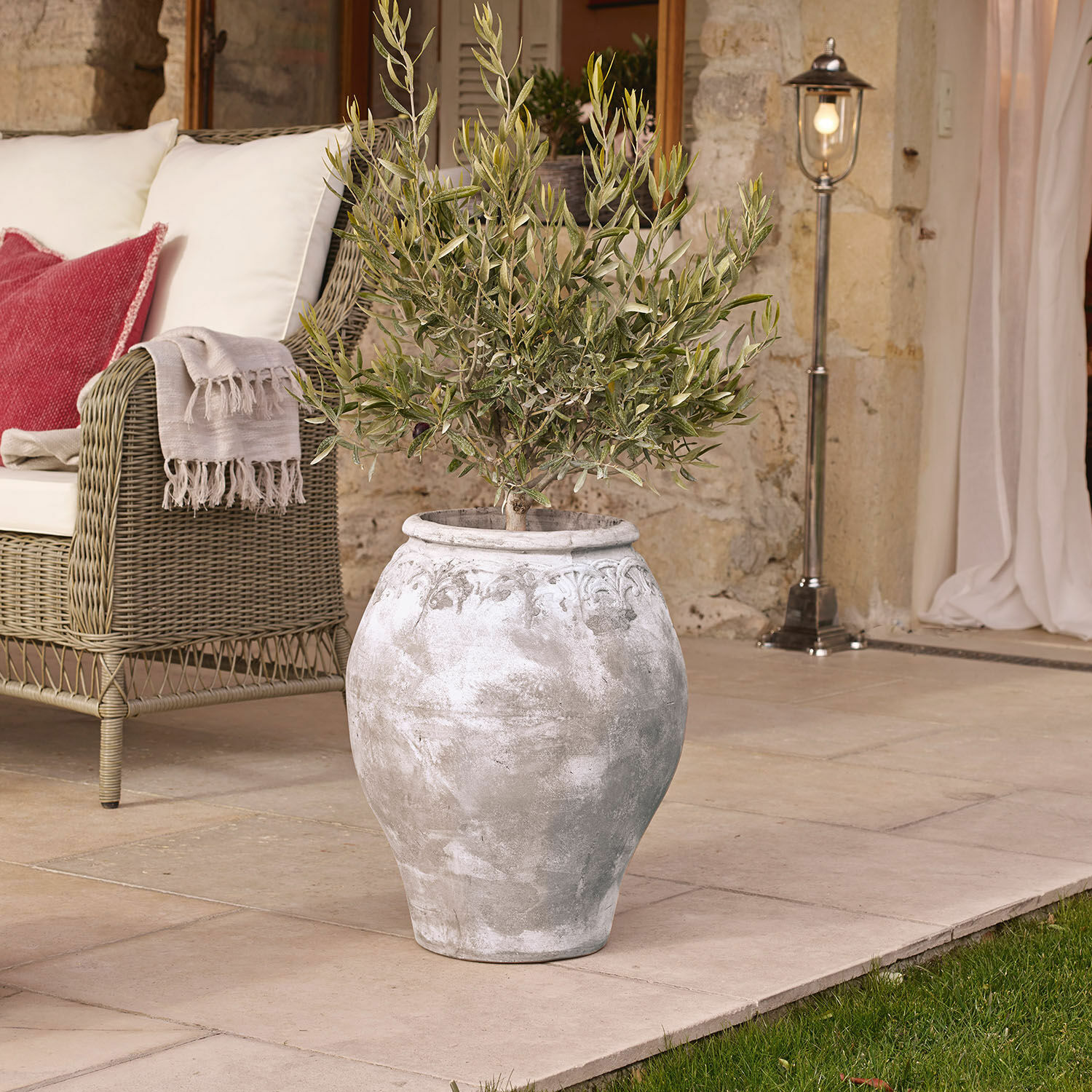 Übertopf Donneville Große graue Keramikvase mit Pflanze auf Terrasse neben Korbsessel mit Kissen