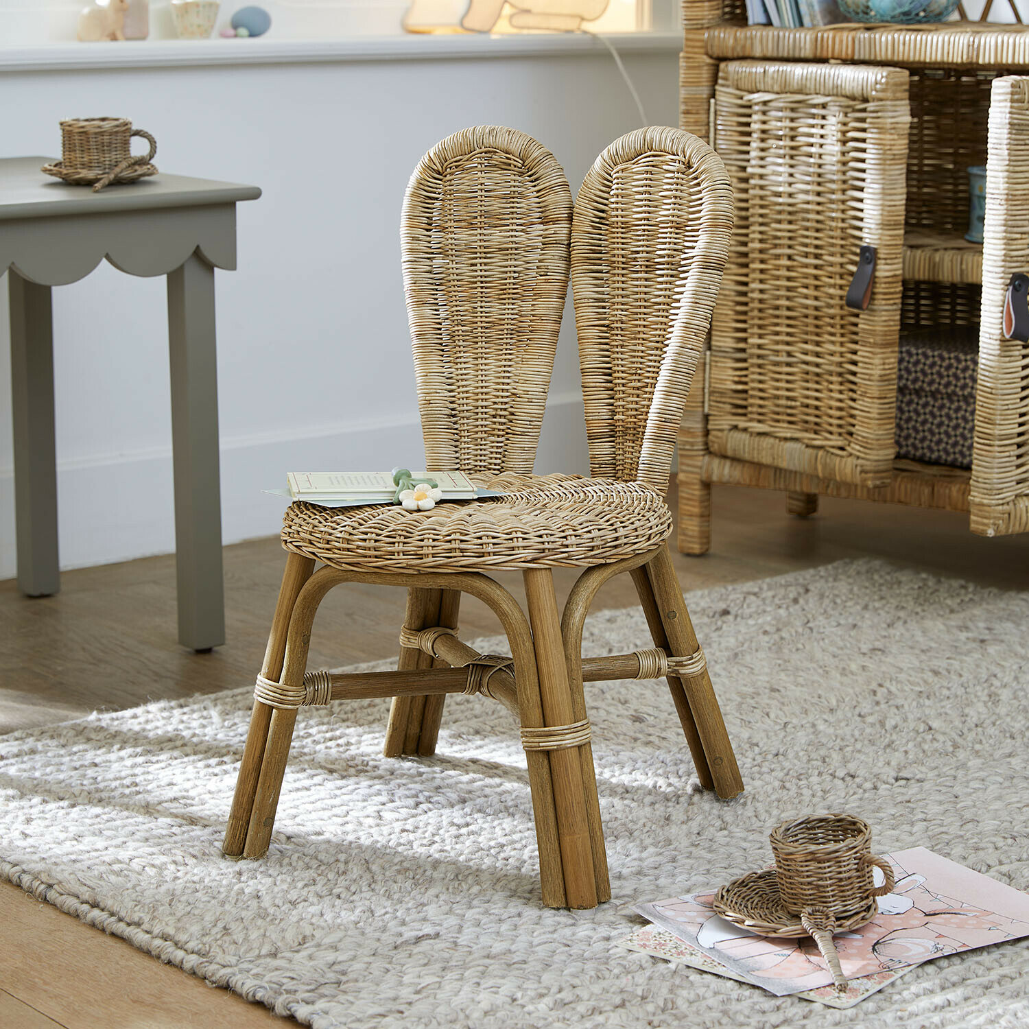 Kinderstuhl aus natürlichem Rattan auf hellem Teppich in einem Kinderzimmer