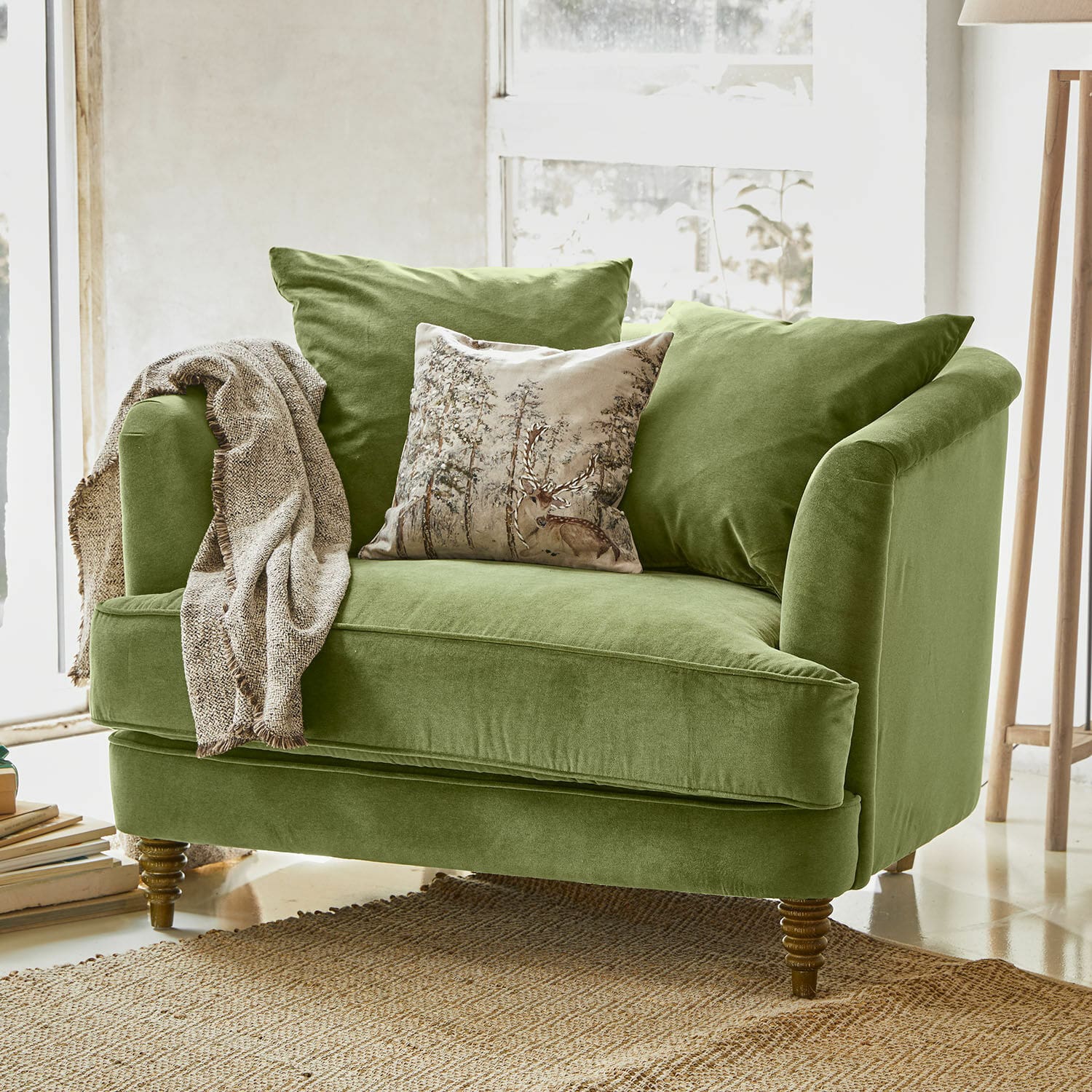 Sessel Etueffont Grünes Samtsofa mit Kissen und beigem Plaid auf Naturteppich in hellem Raum