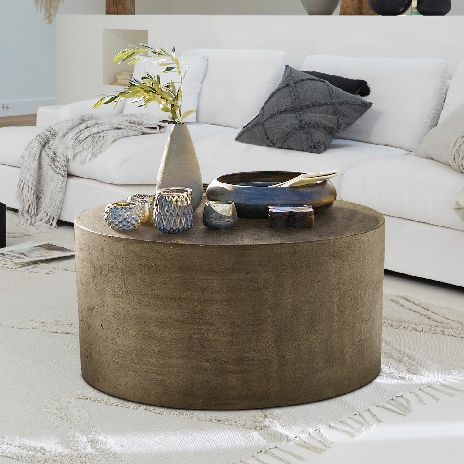 Couchtisch Lexy Runder Couchtisch aus braunem Beton auf hellem Teppich im modernen Wohnzimmer mit weißem Sofa