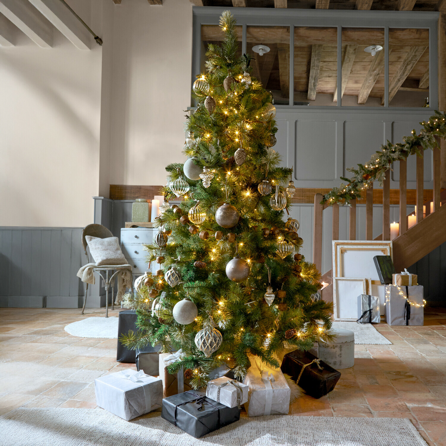 Weihnachtsbaum Aure Geschmückter Weihnachtsbaum mit grünen Zweigen und goldenen Lichtern in gemütlichem Raum mit Geschenken
