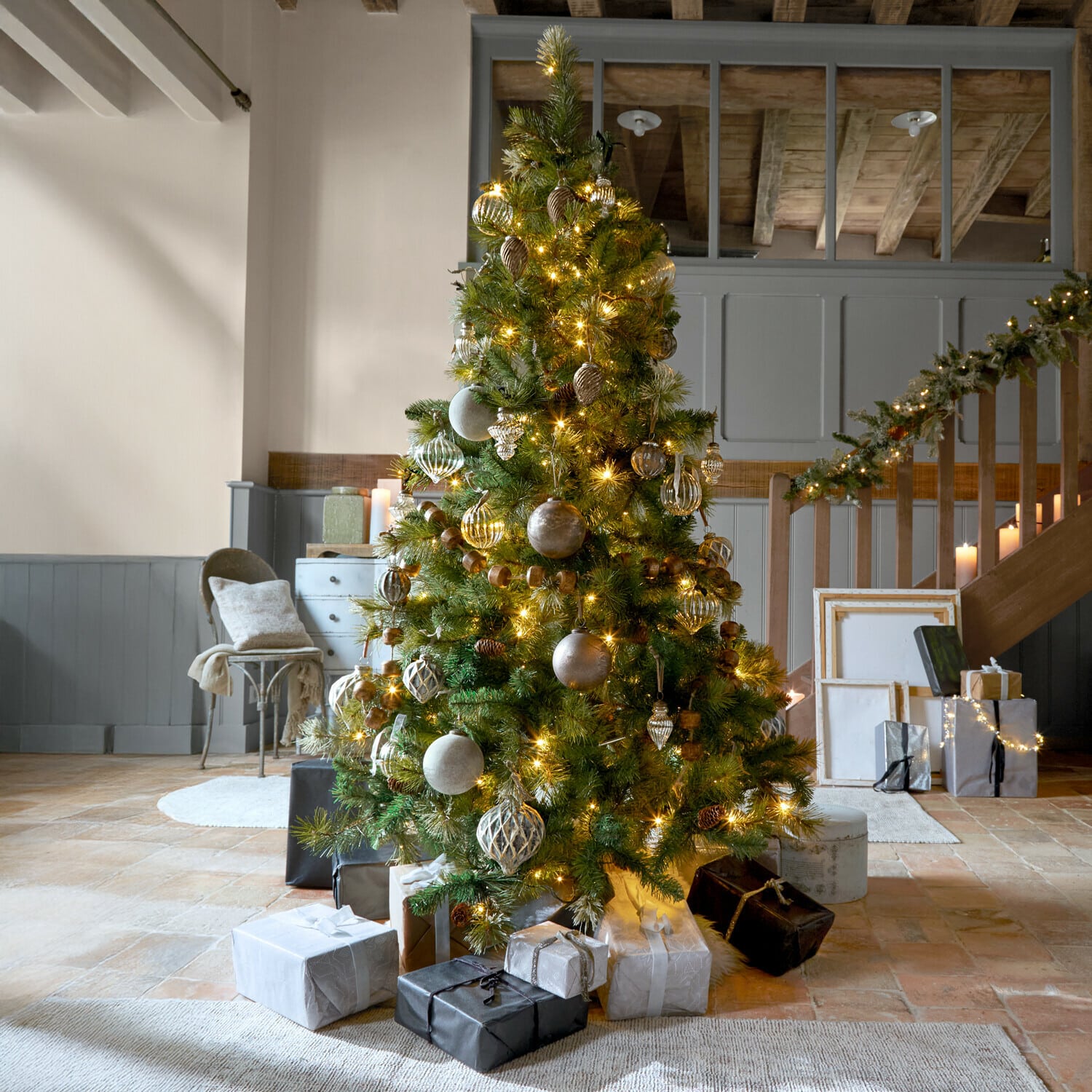 Weihnachtsbaum Aure Geschmückter Weihnachtsbaum mit grünen Zweigen und goldenen Lichtern in gemütlichem Raum mit Geschenken