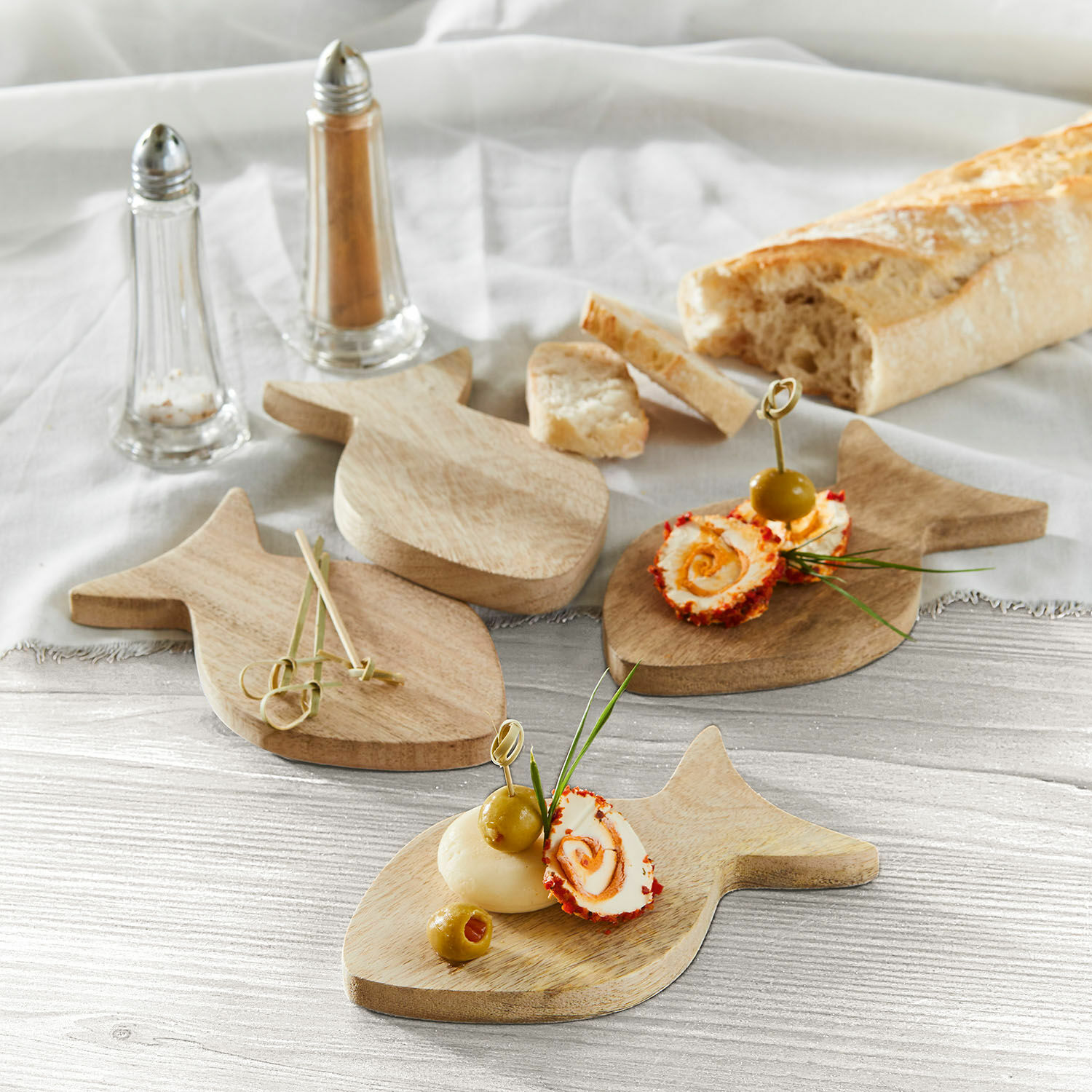 Untersetzer 4er Set Magnan Holz-Servierbretter in Fischform mit Oliven und Käsehäppchen auf Tisch