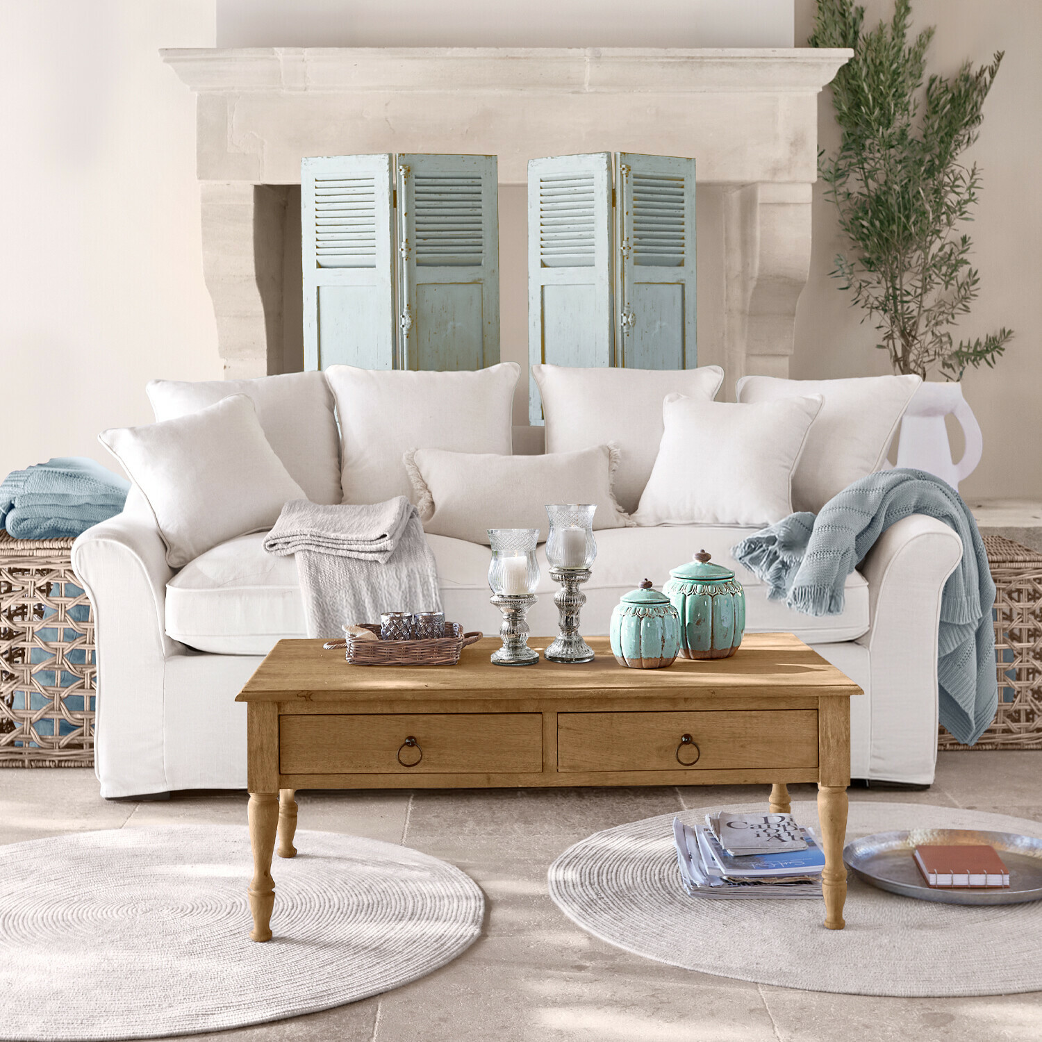 Sofa Long Beach Beiges Sofa mit Kissen und Holzcouchtisch mit Dekoration in hellem Wohnzimmer mit Kamin