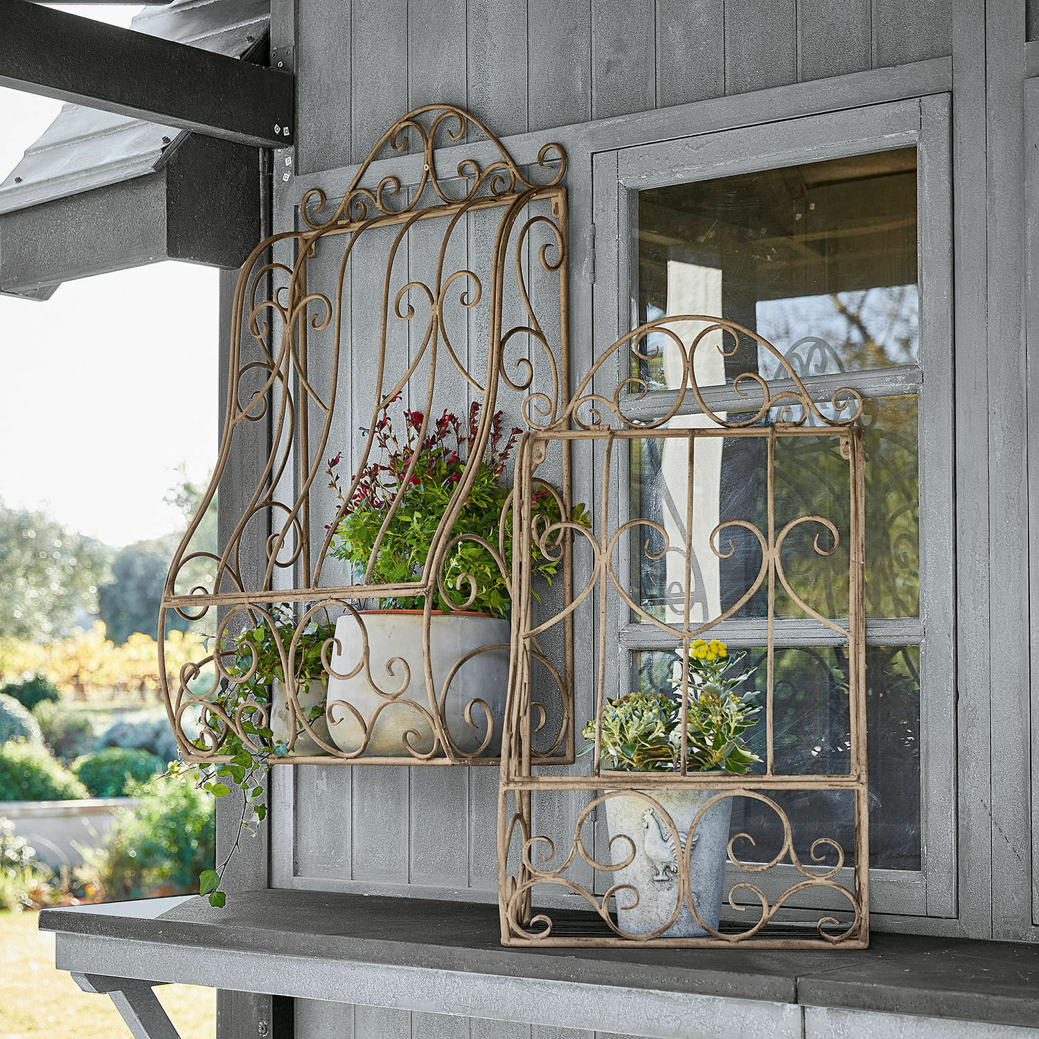 Wandregal 2er Set Alvra Beige Metall-Dekorahmen mit Pflanzen vor grauer Holzwand, dekoratives Gartenelement