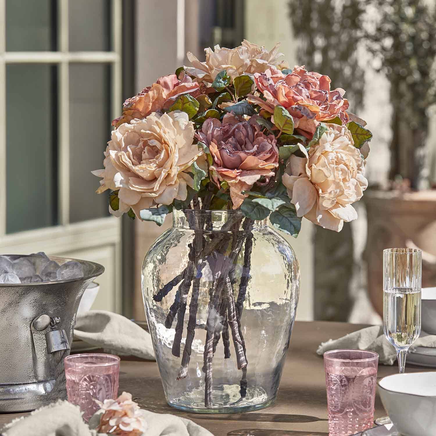 Rosenstrauß in klarem Glasvase auf Tisch, pastellfarbene Blumen-Dekoration für Zuhause