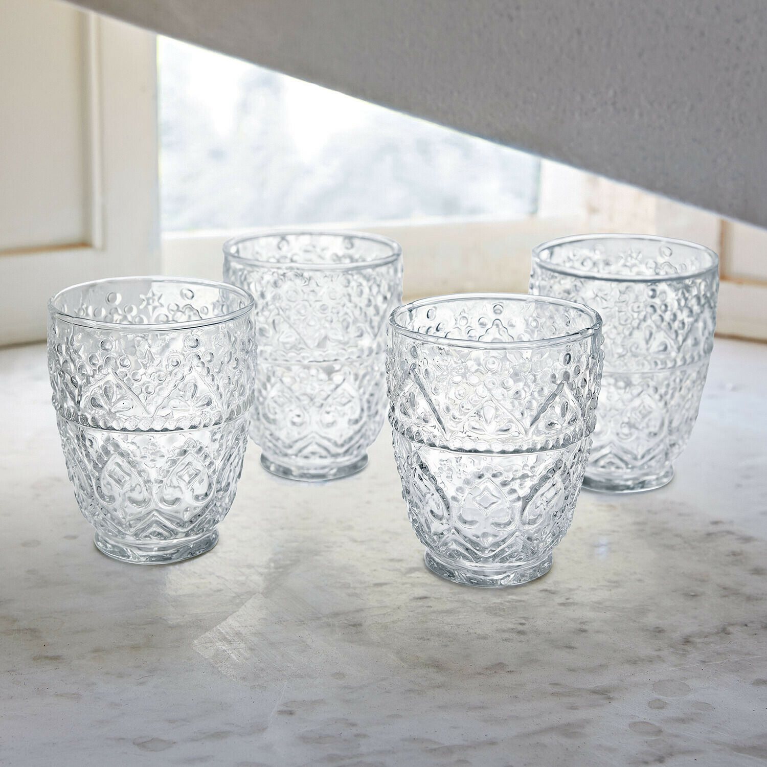 Glas 4er Set Rivoux Gläser mit Rotwein und Flasche auf weißem Tisch mit dekorativen Metalllampen im Garten