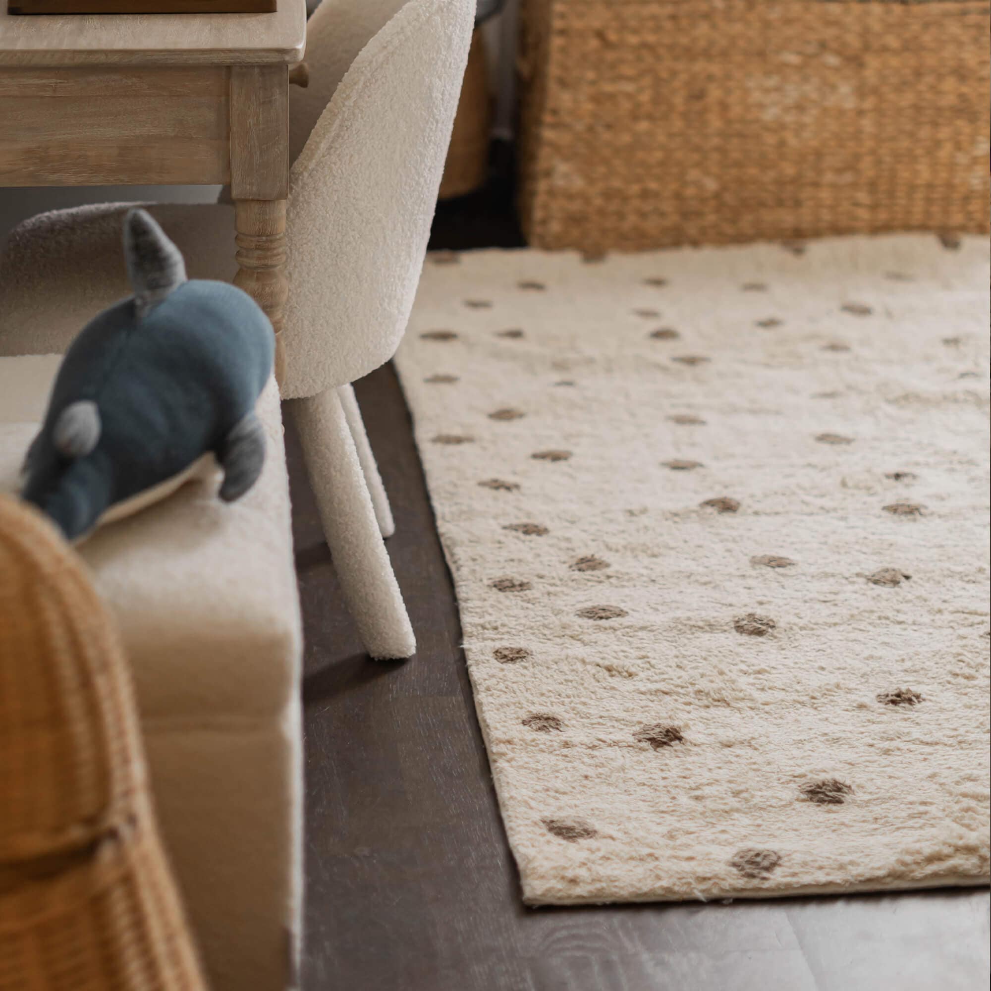 Beiger Teppich aus weichem Material mit braunen Punkten auf dunklem Boden im Wohnzimmer