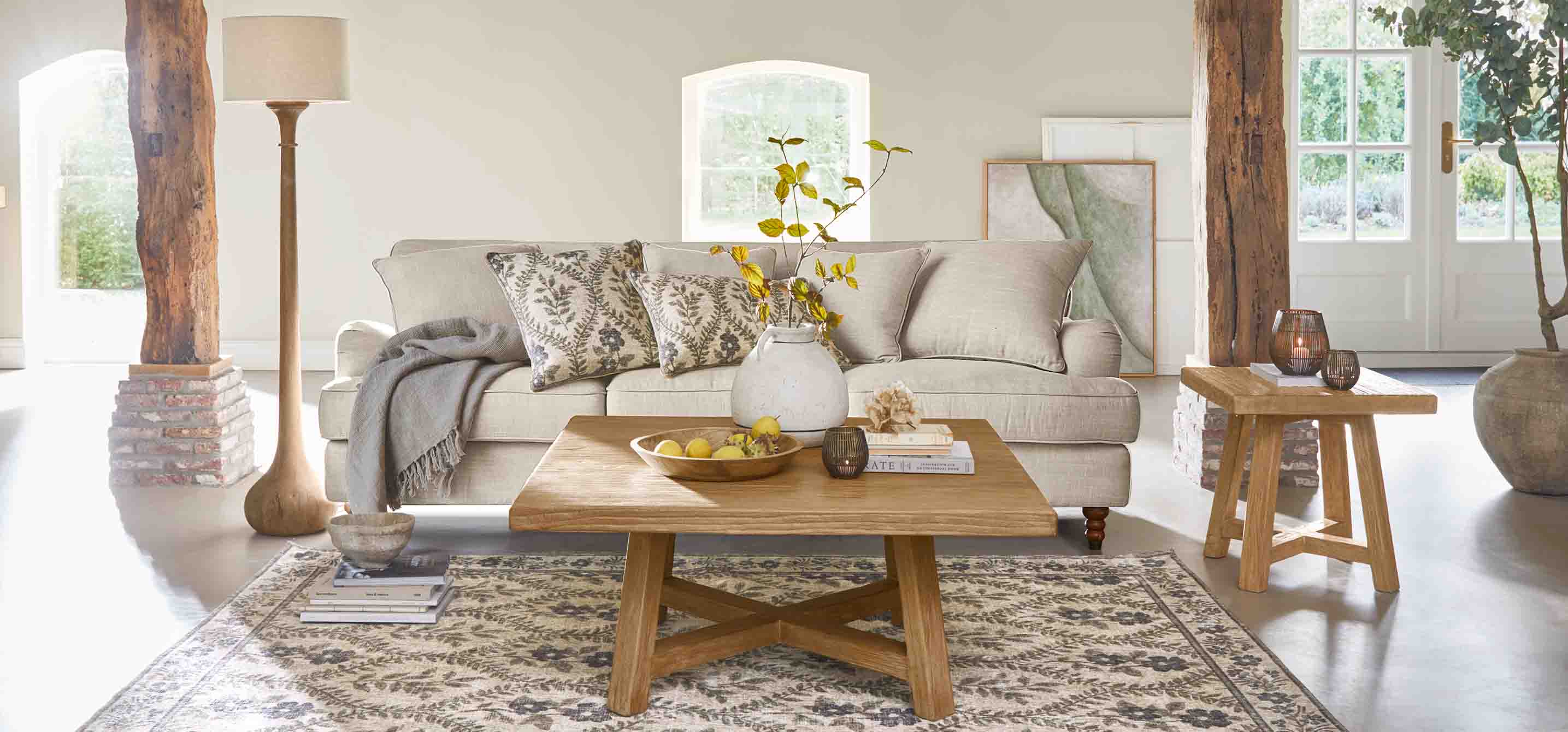 Gemütliches Wohnzimmer mit beigem Sofa, Holztisch und natürlichen Dekorationen im rustikalen Stil