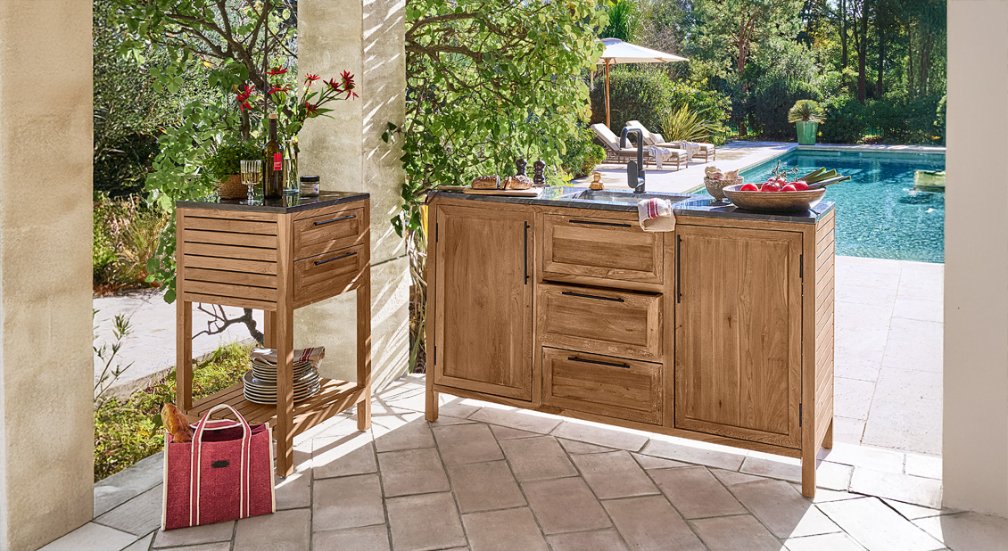 Outdoor-Küche aus Teakholz mit schwarzer Arbeitsplatte und Schränken auf Terrasse neben Pool
