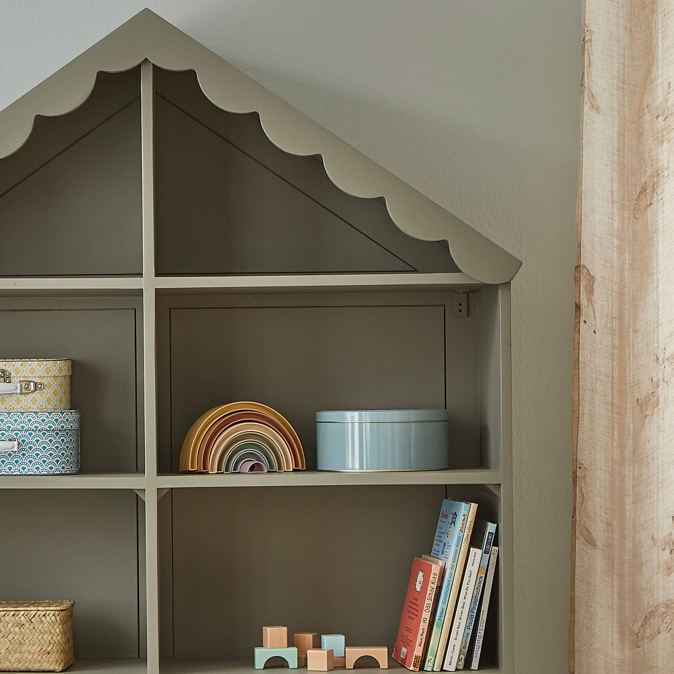 Graues Holzregal in Hausform mit Spielzeug und Büchern für Kinderzimmer