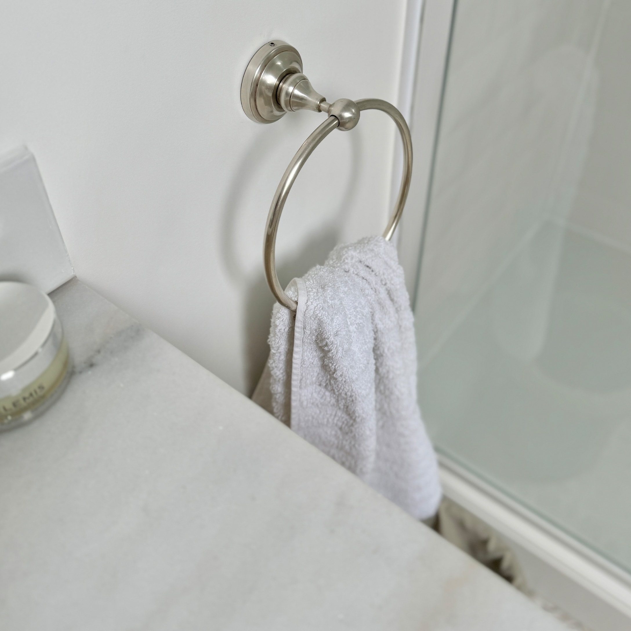 Metall-Handtuchhalter mit weißem Handtuch und Marmorarbeitsplatte im Badezimmer