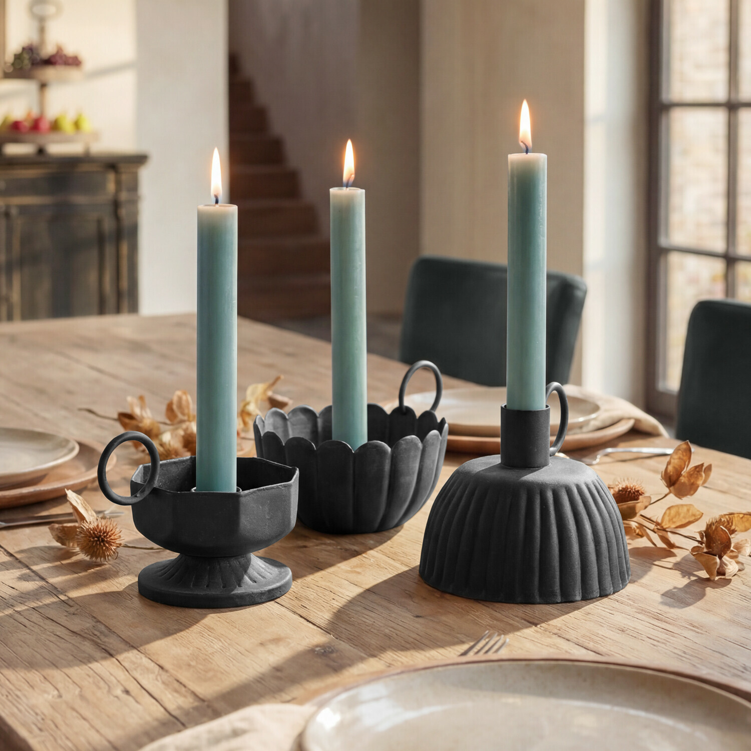 Kerzenhalter 3er Set Lazharin Drei schwarze Metallkerzenhalter mit grünen Kerzen auf einem Holztisch im Esszimmer