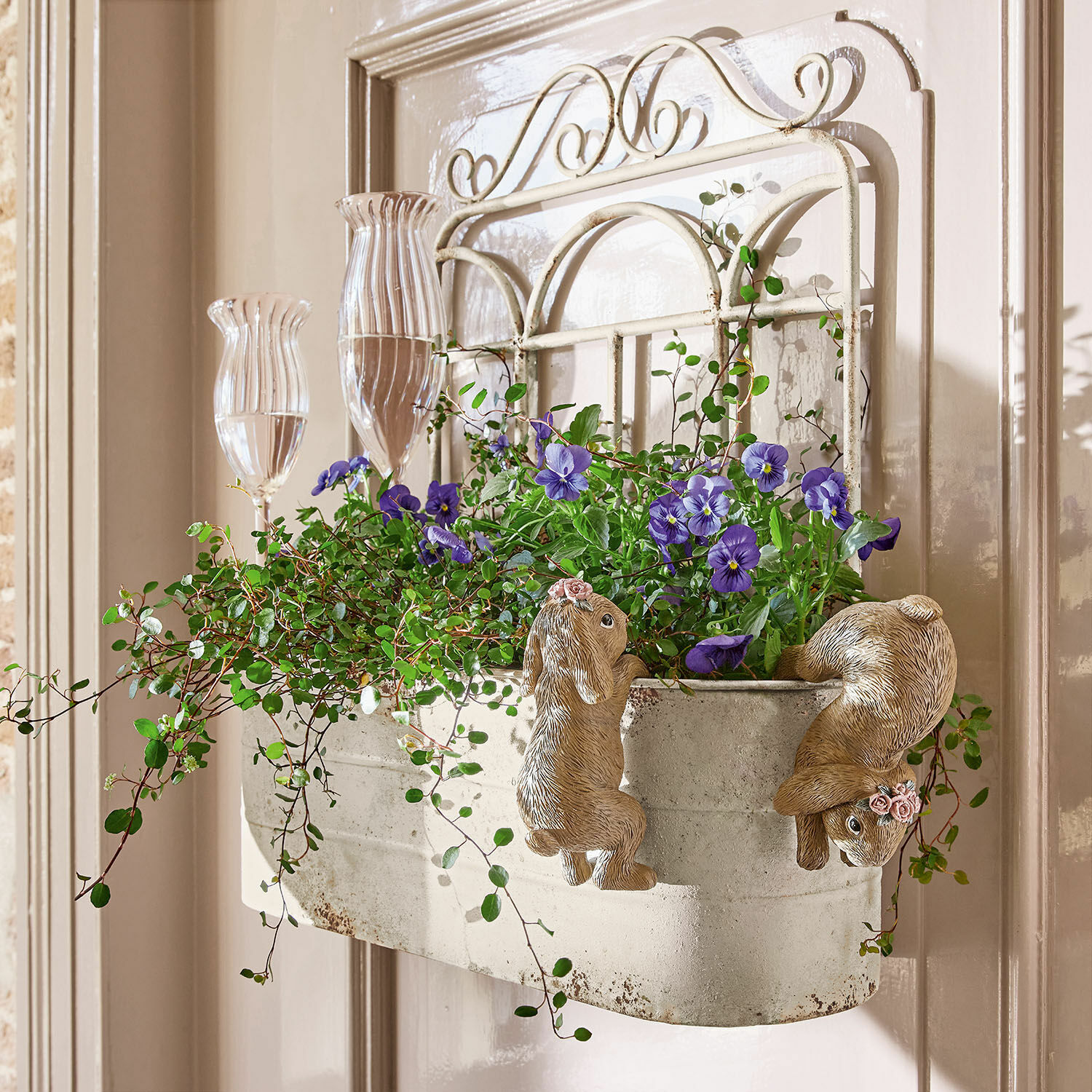 Pflanzkorb Marwin Metall-Wandblumentopf mit Hasen-Dekor und violetten Blumen vor hellem Türhintergrund