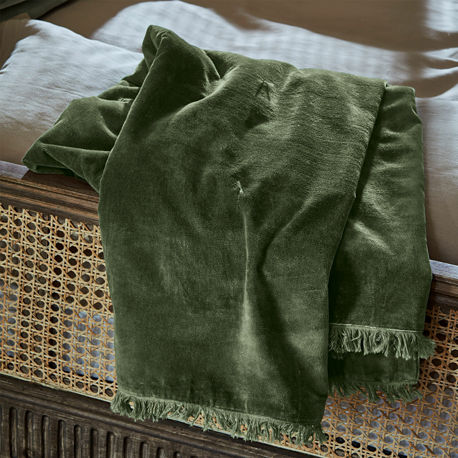 Plaid Maelis Grüne Samtdecke mit Fransen auf Holzbett, weicher dekorativer Wohntextil für Schlafzimmer