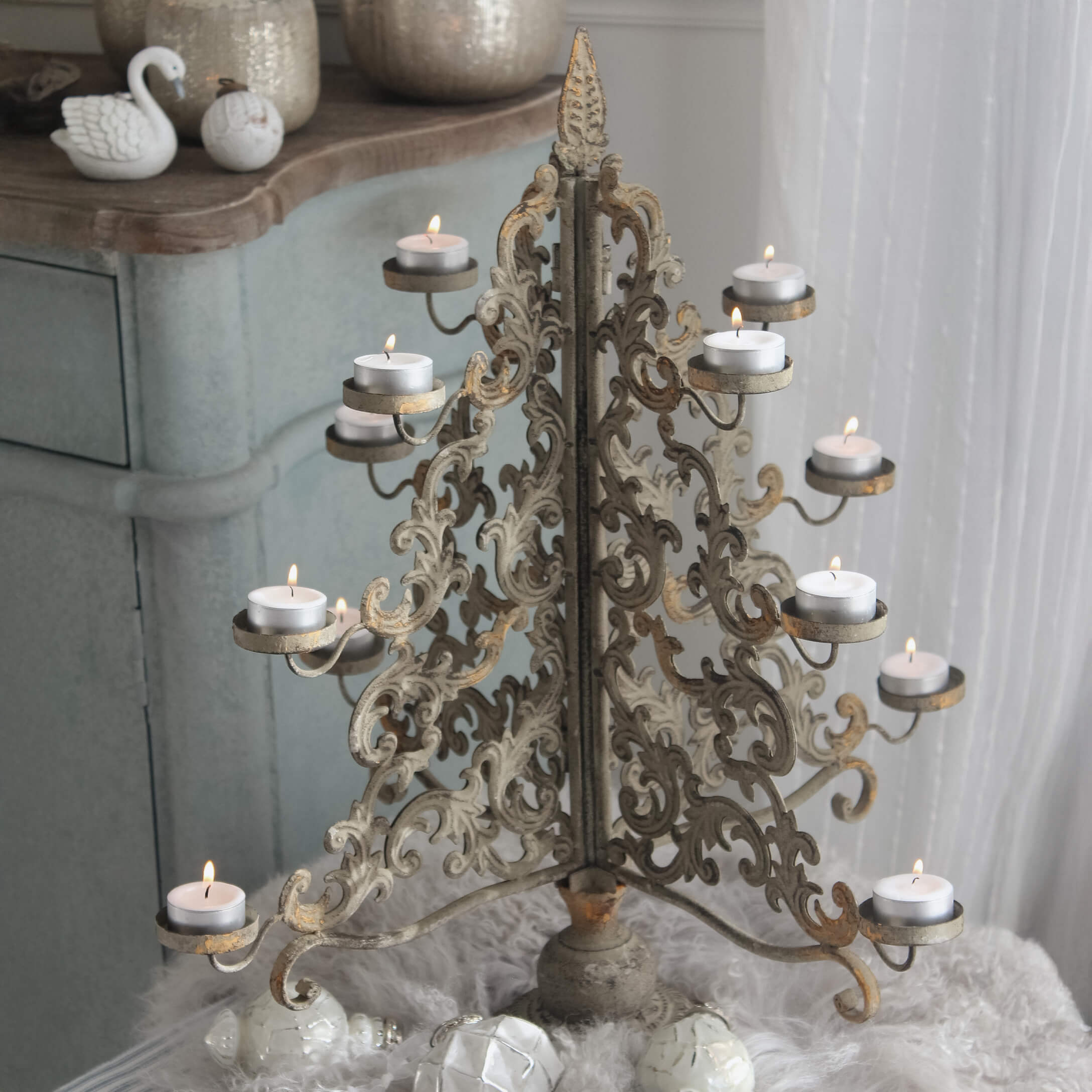 Metall-Kerzenhalter mit filigranem Muster in antikgold und brennenden Teelichtern