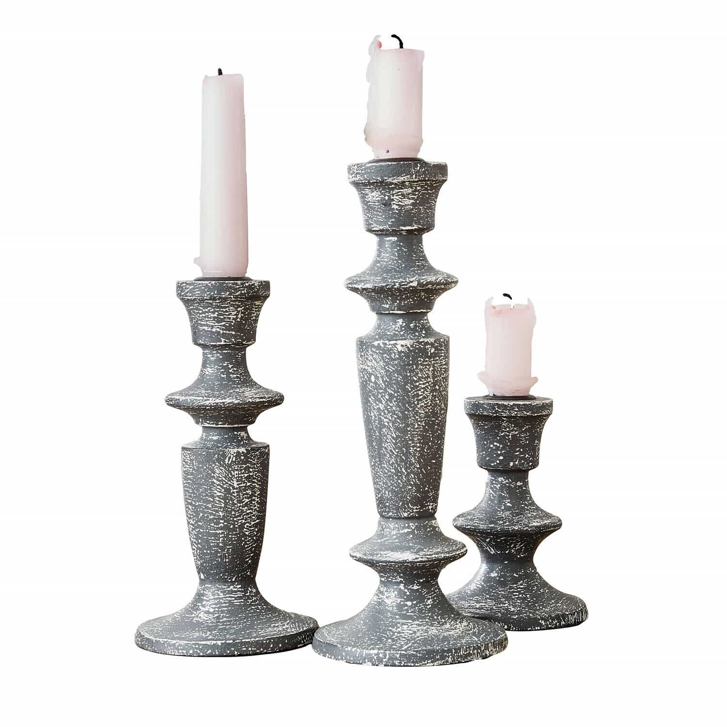Set aus drei grauen Kerzenhaltern aus antik wirkendem Holz mit rosa Kerzen für Wohnraum