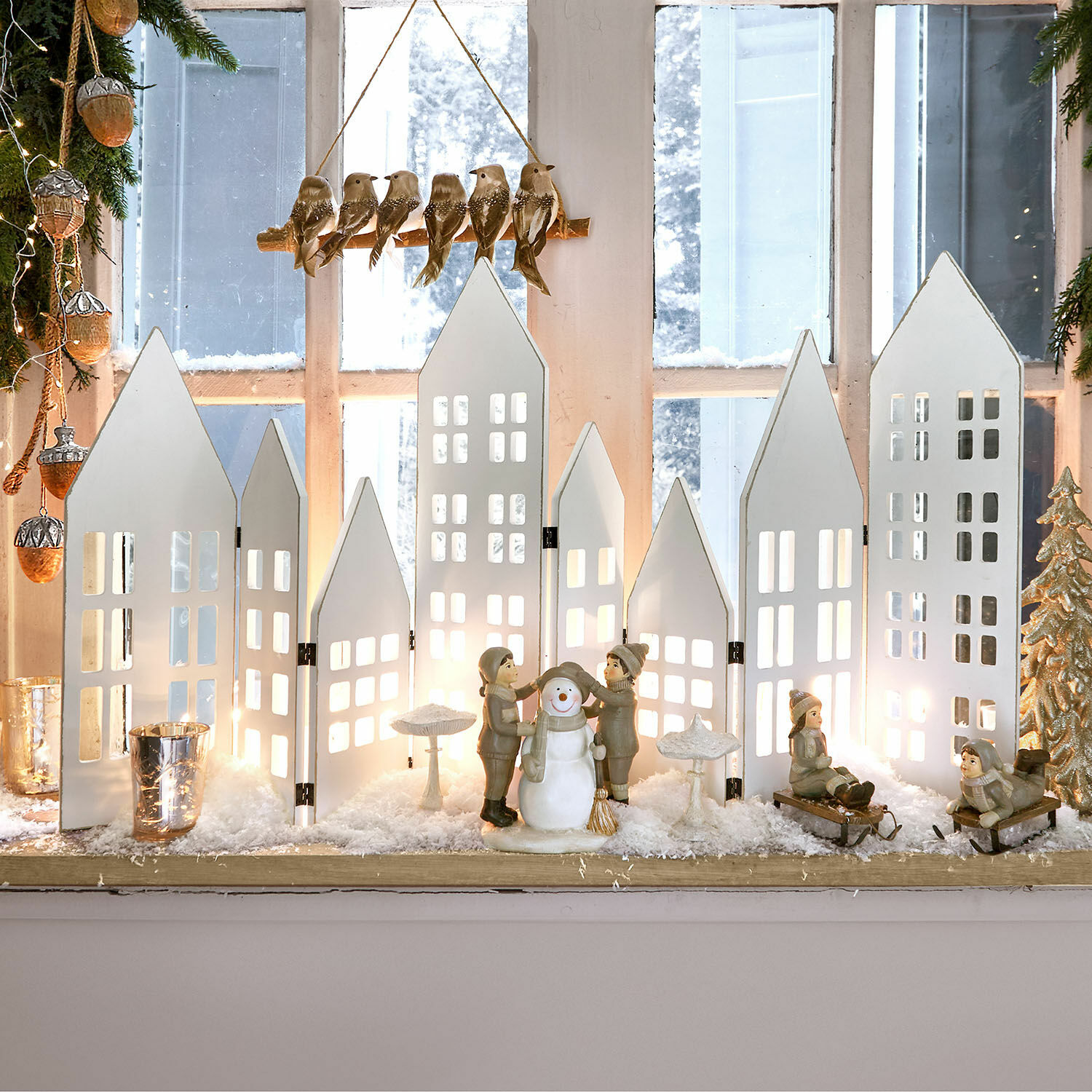 Deko-Shutter Cottages Winterliche Dekoration mit weißen Holz-Häusern und Kinderfiguren mit Schneemann auf Fensterbank