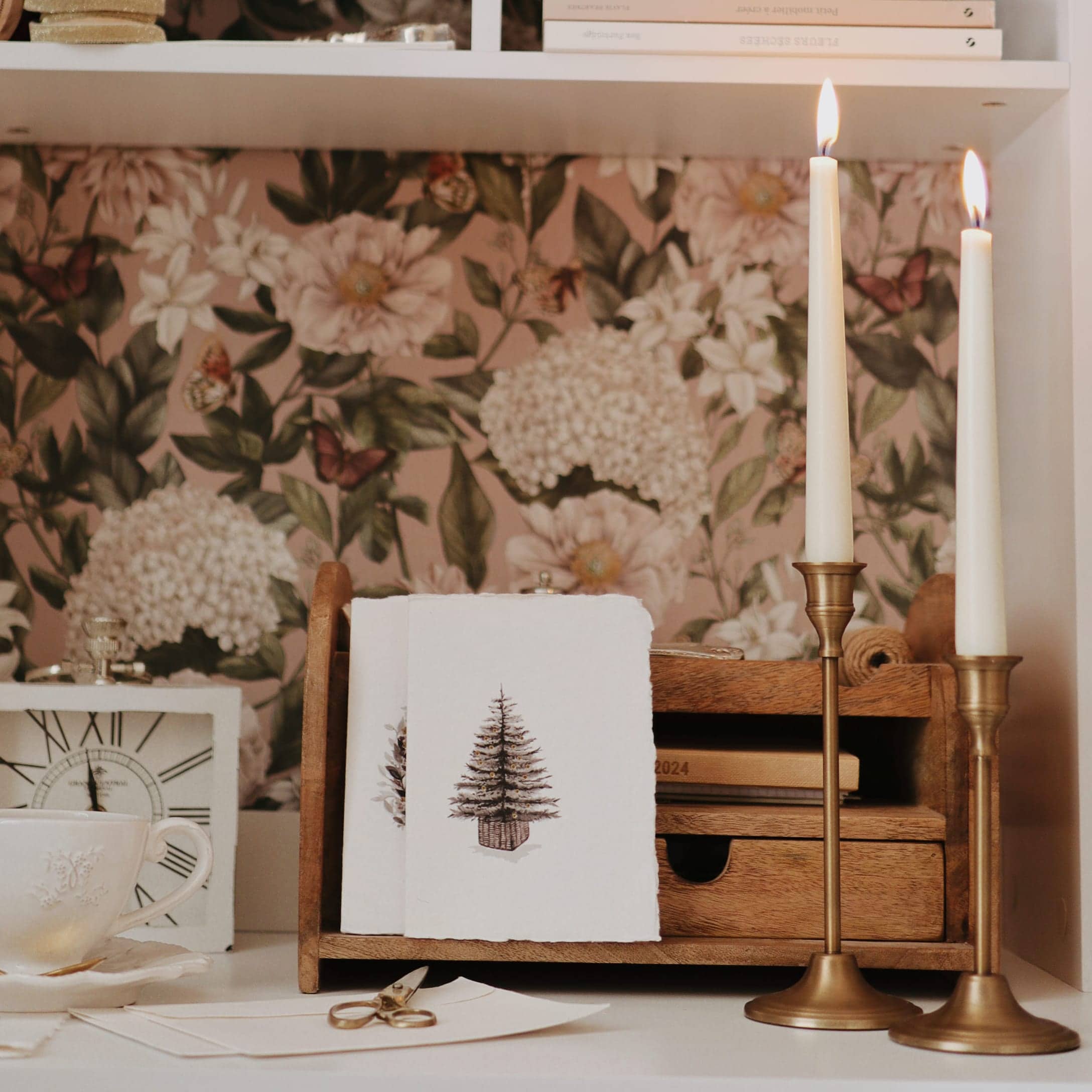 Holz-Organizer mit Weihnachtskarten und zwei goldenen Kerzenhaltern auf weißem Hintergrund