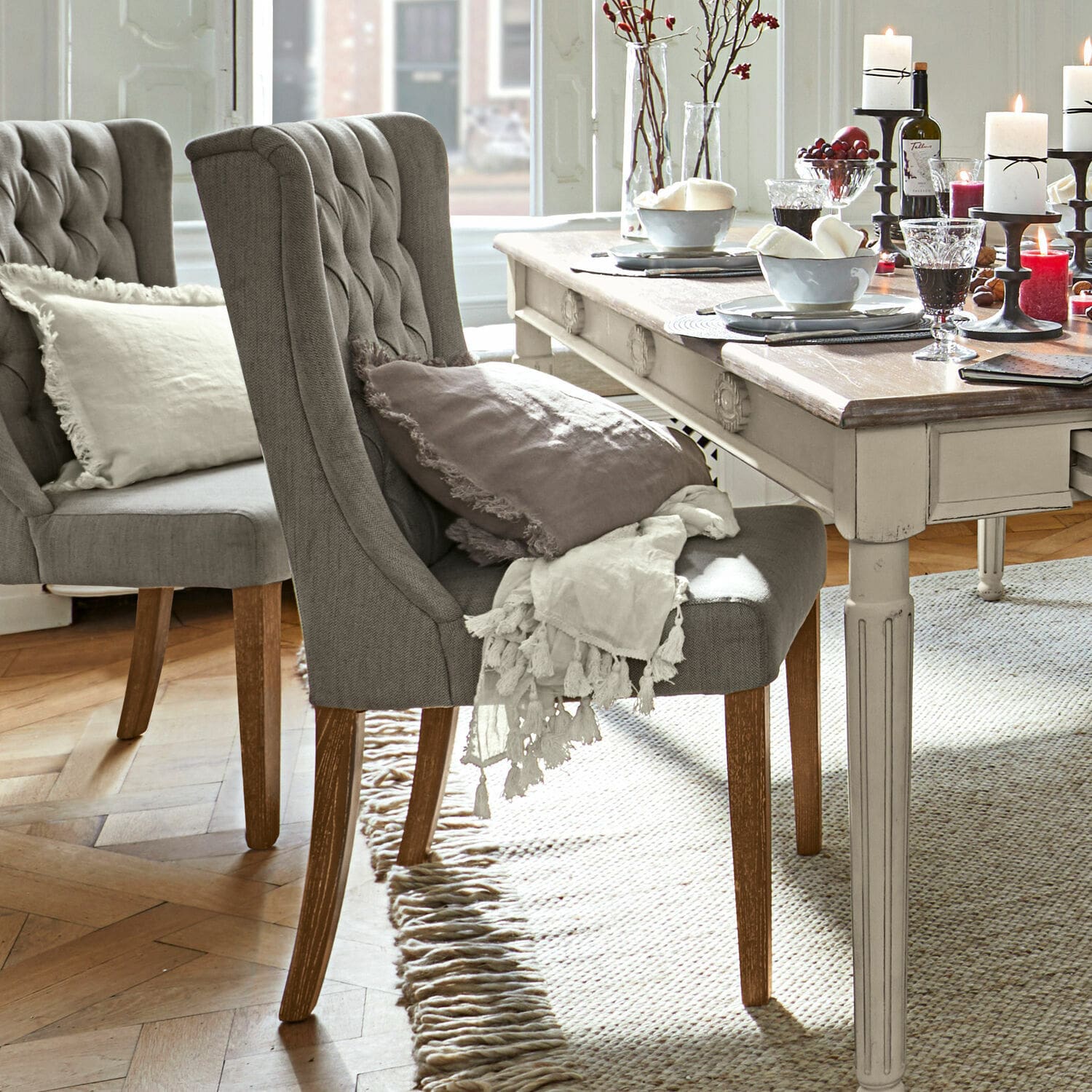 Stuhl Sudbury Grau gepolsterter Stuhl mit Holzbeinen an hellem Vintage-Tisch, Dekorationen auf dem Tisch