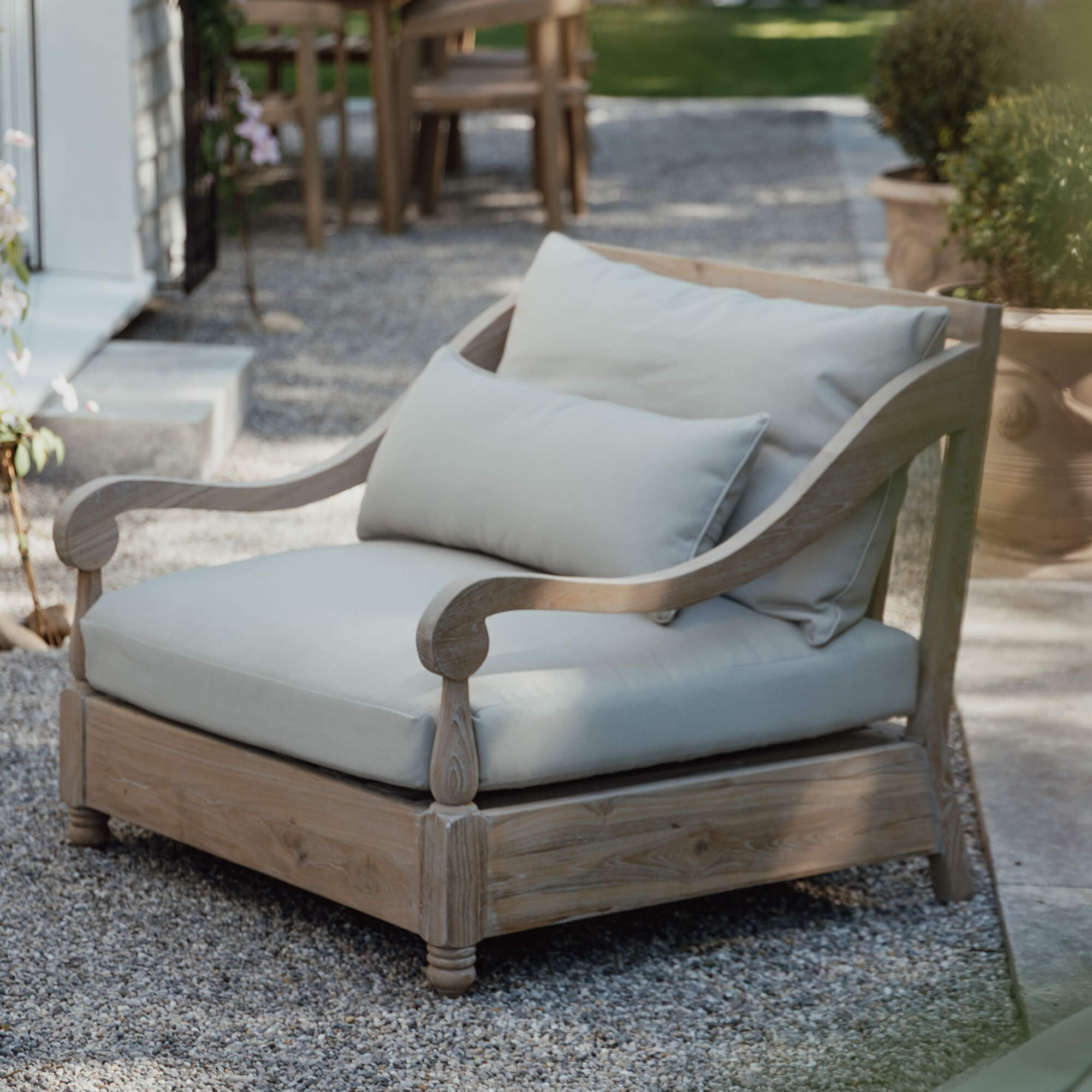 Garten-Sofa aus hellem Holz mit cremefarbenen Kissen, bequeme Terrassenmöbel
